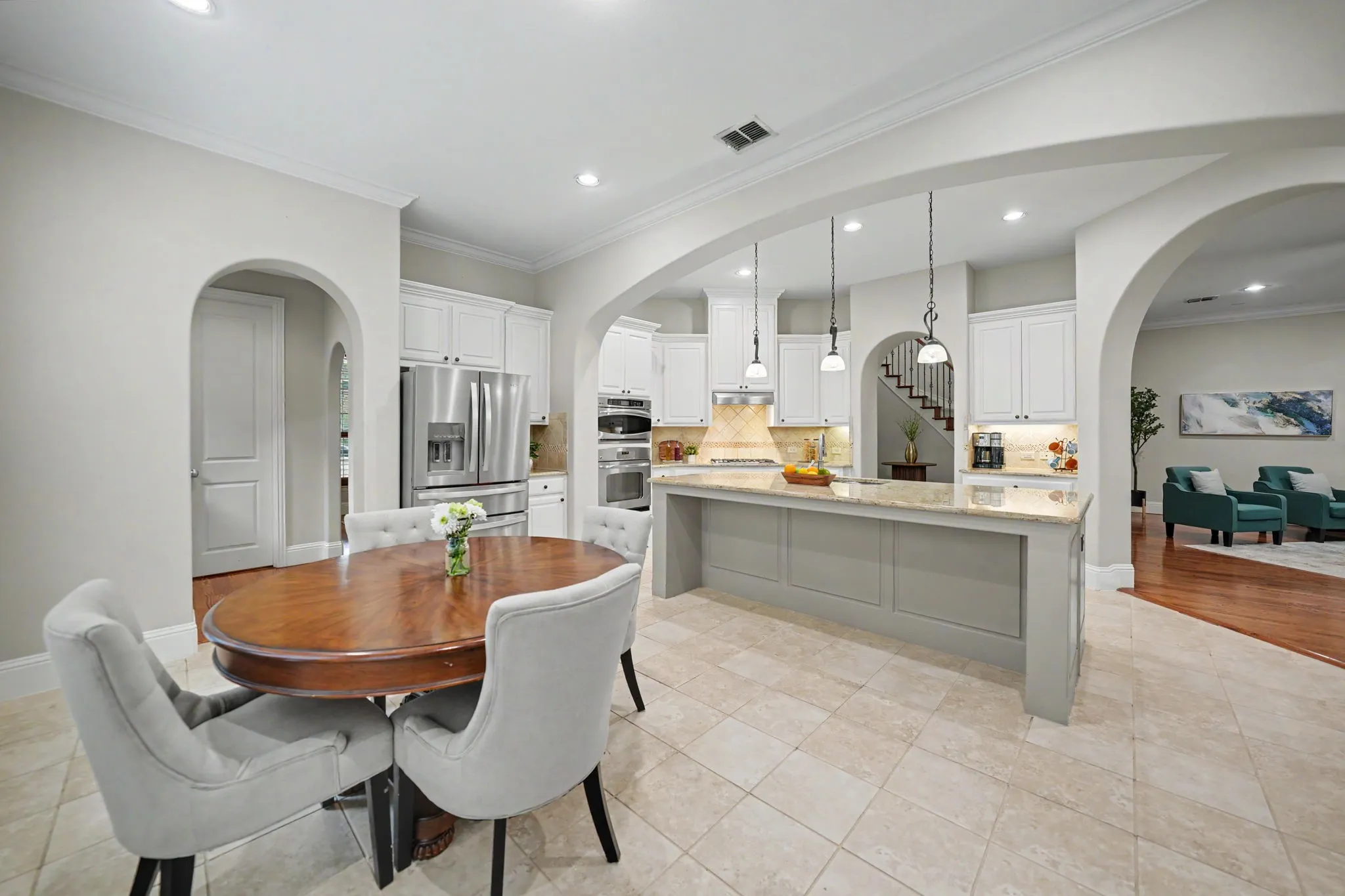 Arched doorways, recessed lighting, and tile flooring define this space