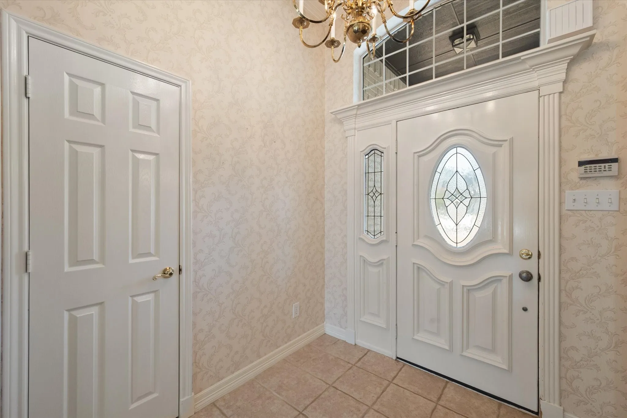 Bright entry with ceramic tile flooring and beautiful wood moldings & trim