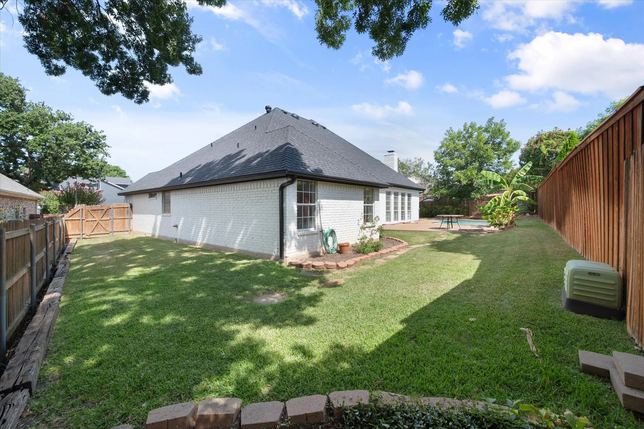 Private backyard with 10 foot rear fence and large grassy area in addition to pool