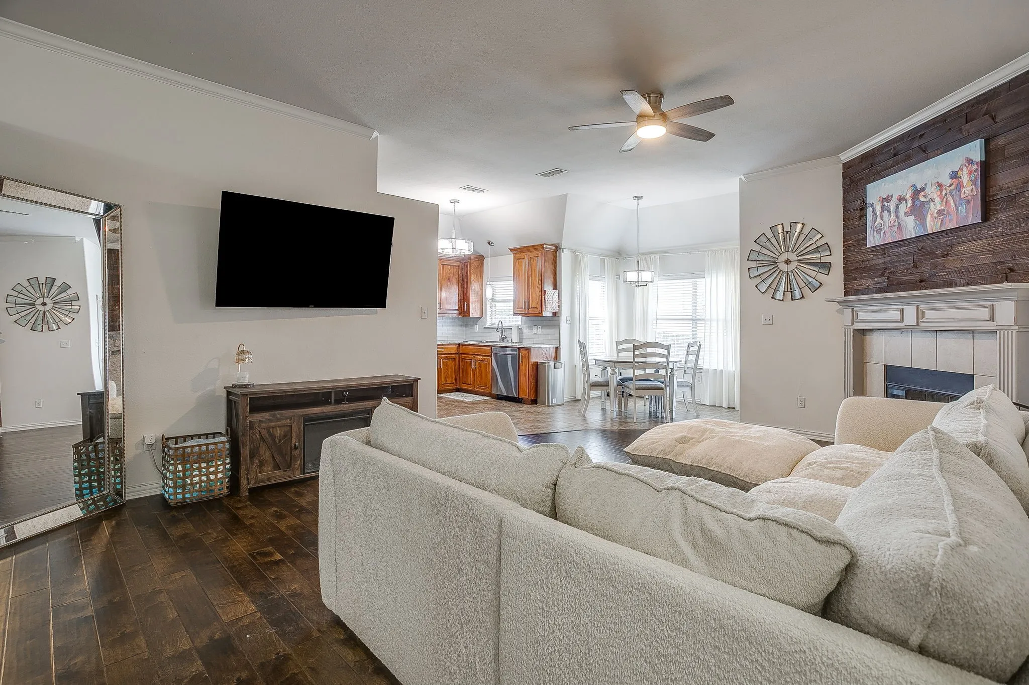 Living area featuring wood-finish flooring, a fireplace with a decorative mantel, and a wood plank accent wall