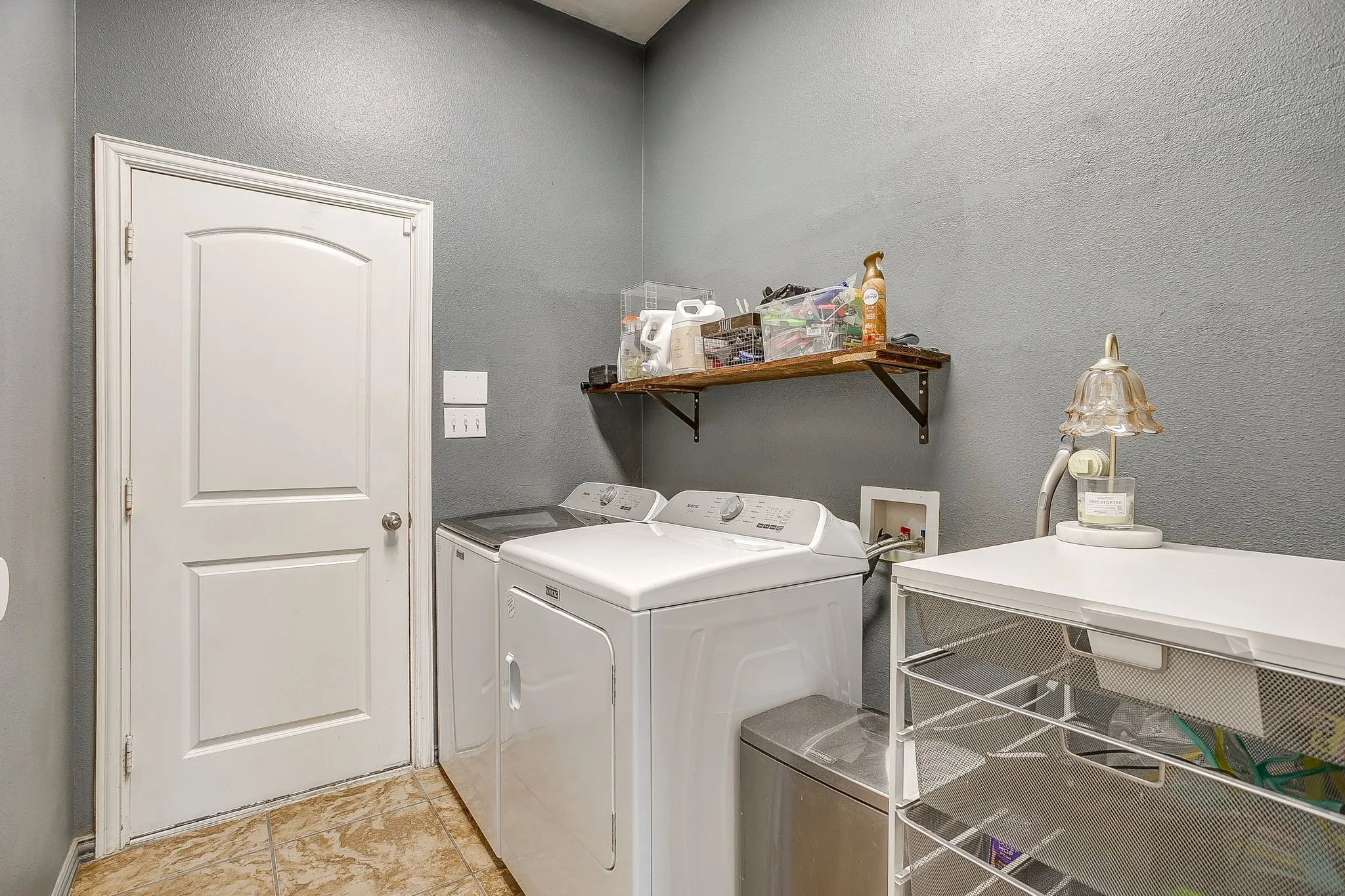 Dedicated utility room featuring light gray walls and durable tile flooring