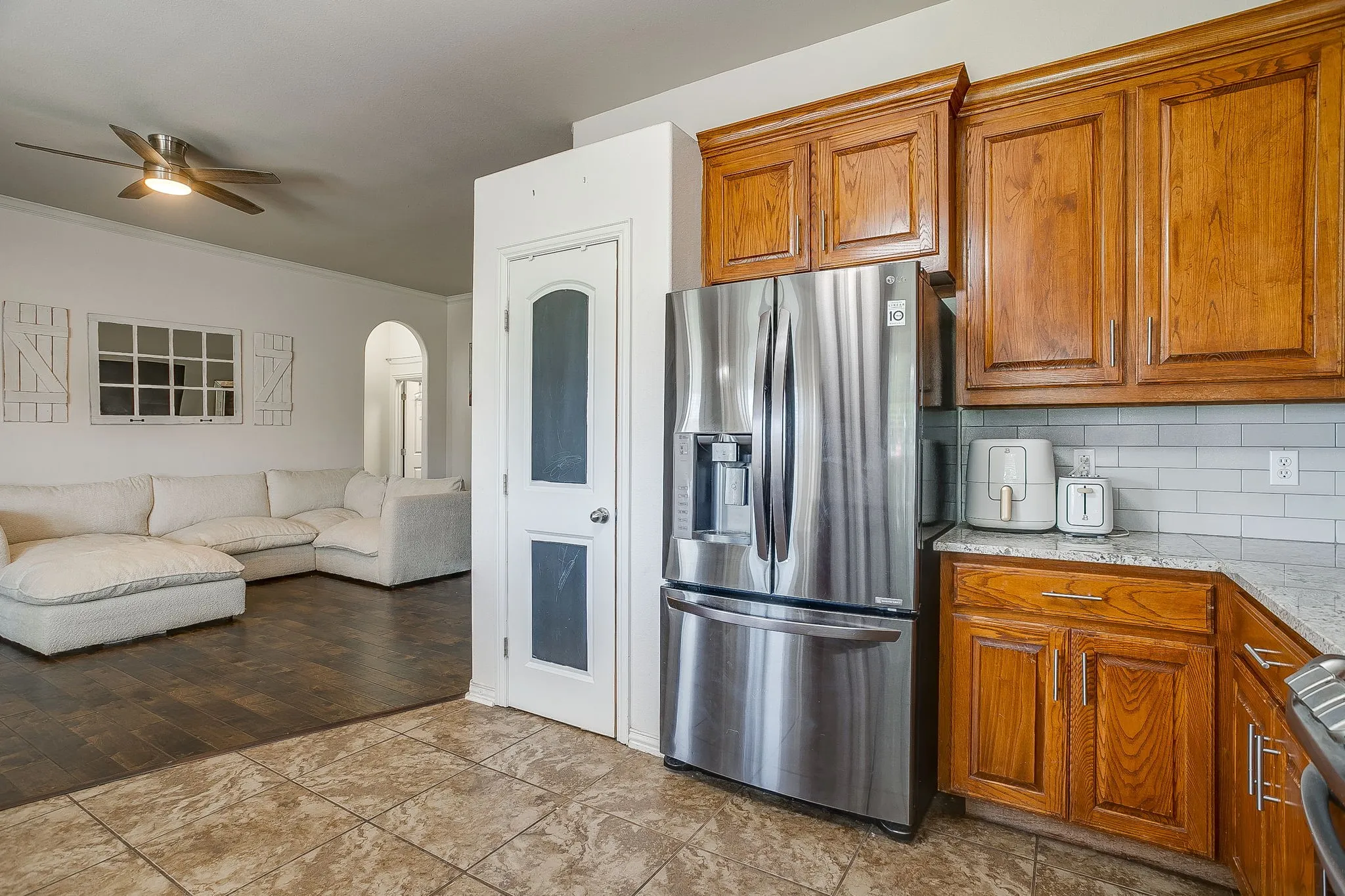 Kitchen featuring wood cabinetry, light-toned countertops, and subway tile backsplash