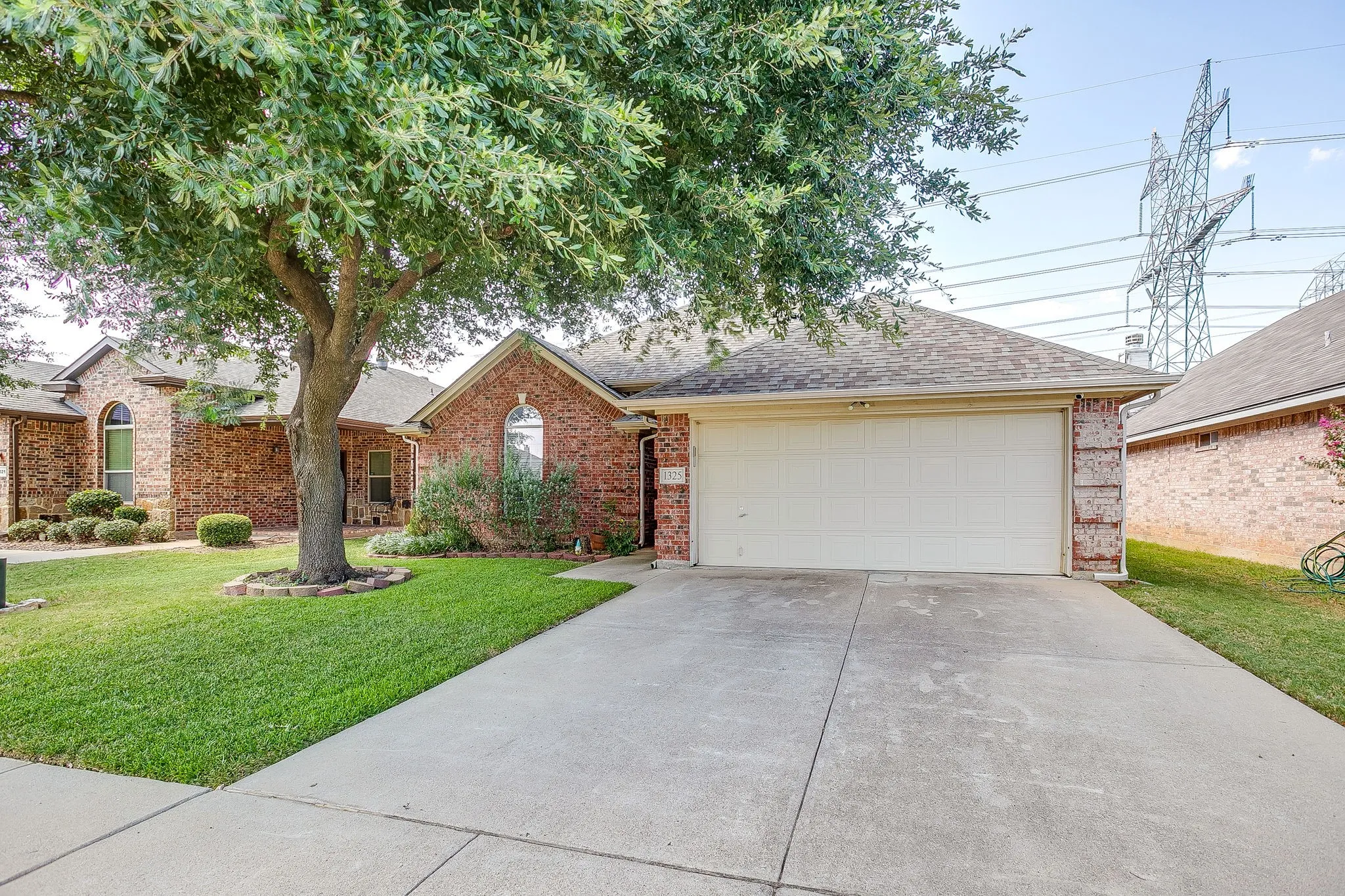 Brick exterior residence featuring an attached garage and concrete driveway