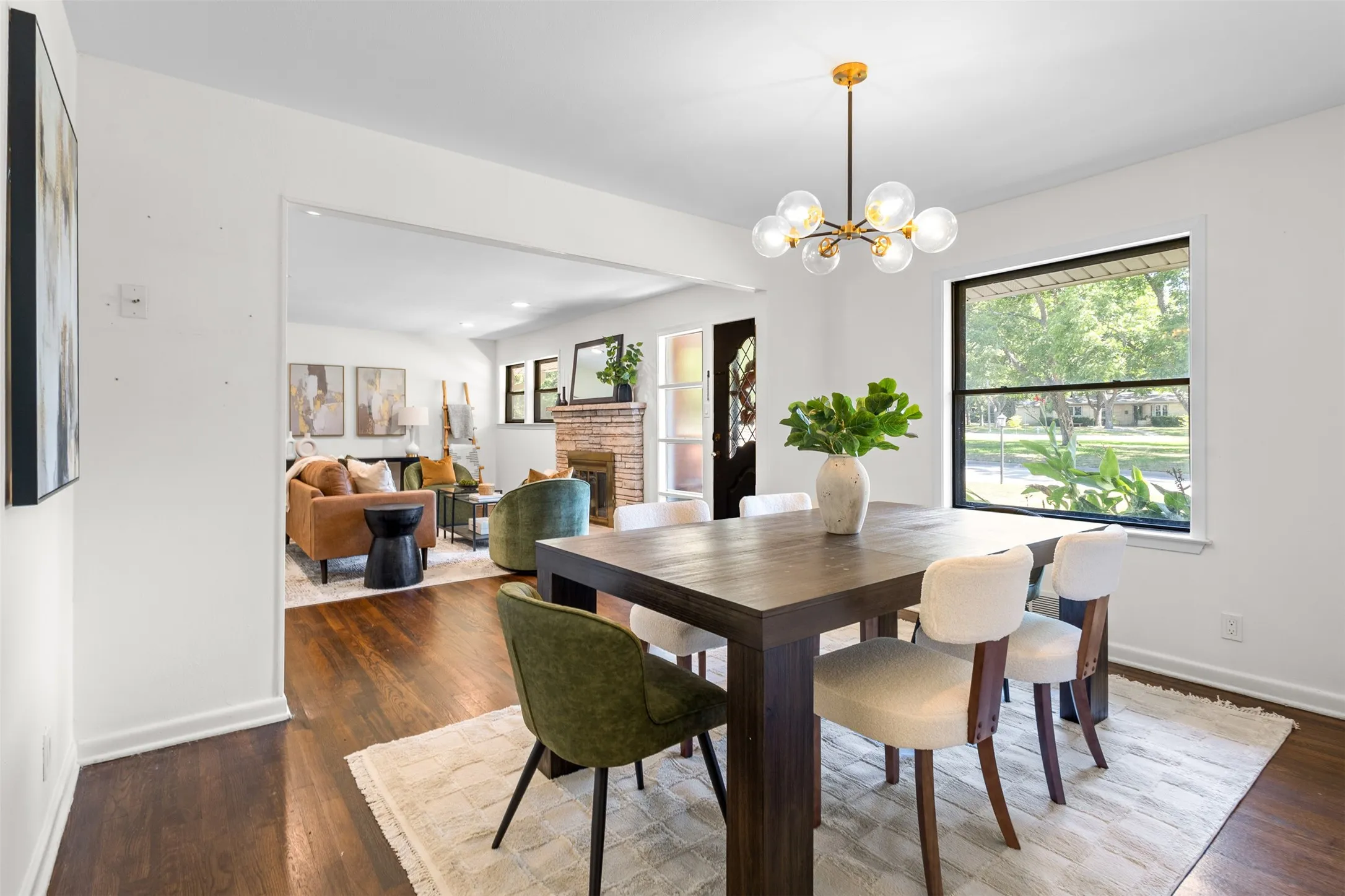Dining area featuring a contemporary chandelier, wood-finish flooring, and a large window
