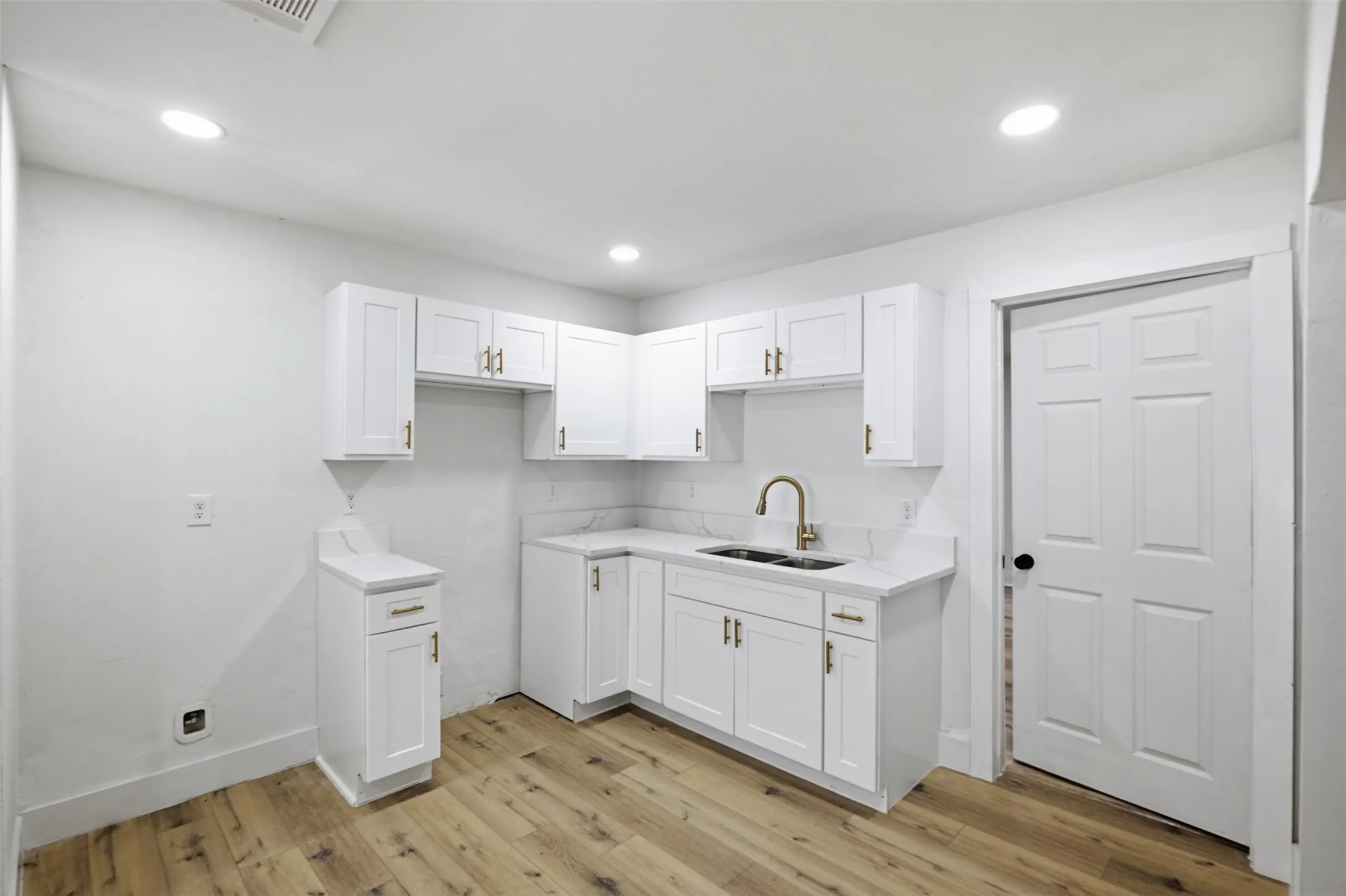 Modern kitchen with white cabinetry and gold-tone hardware