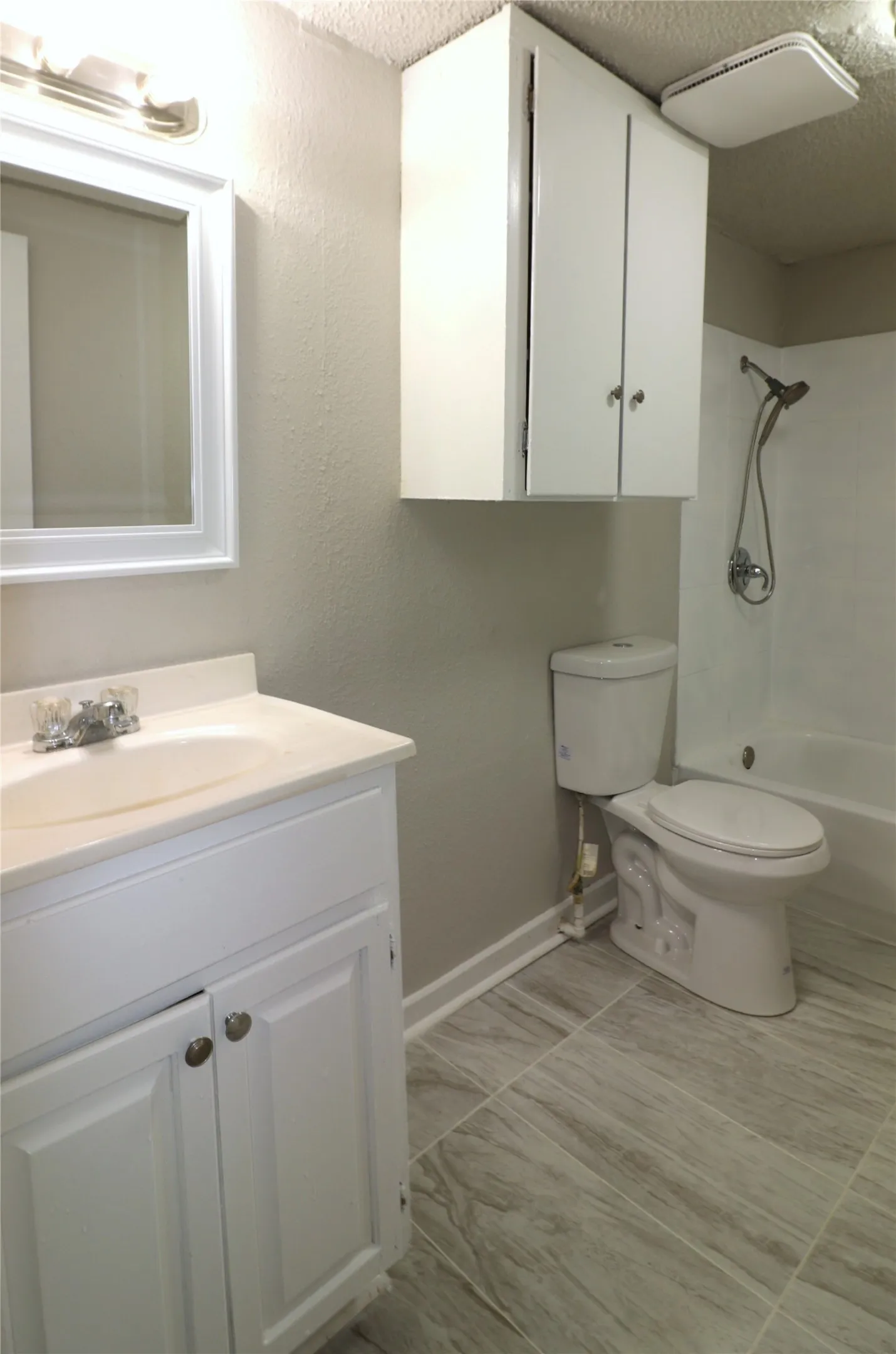 Bathroom with vanity, a textured ceiling, and bathing tub / shower combination