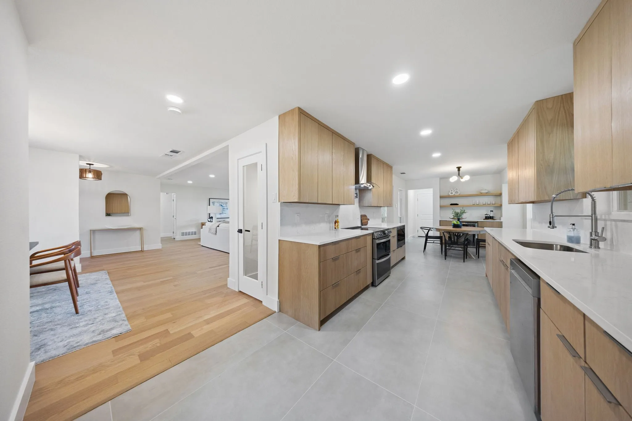 Contemporary kitchen featuring light wood-finish cabinetry, stainless steel appliances, and light-toned countertops