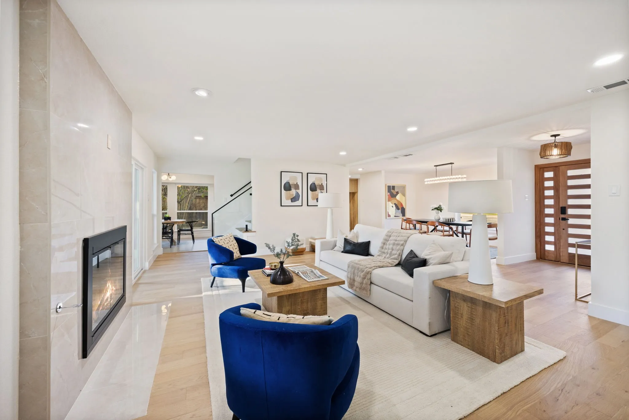 Spacious living area featuring light wood-finish flooring and recessed lighting throughout