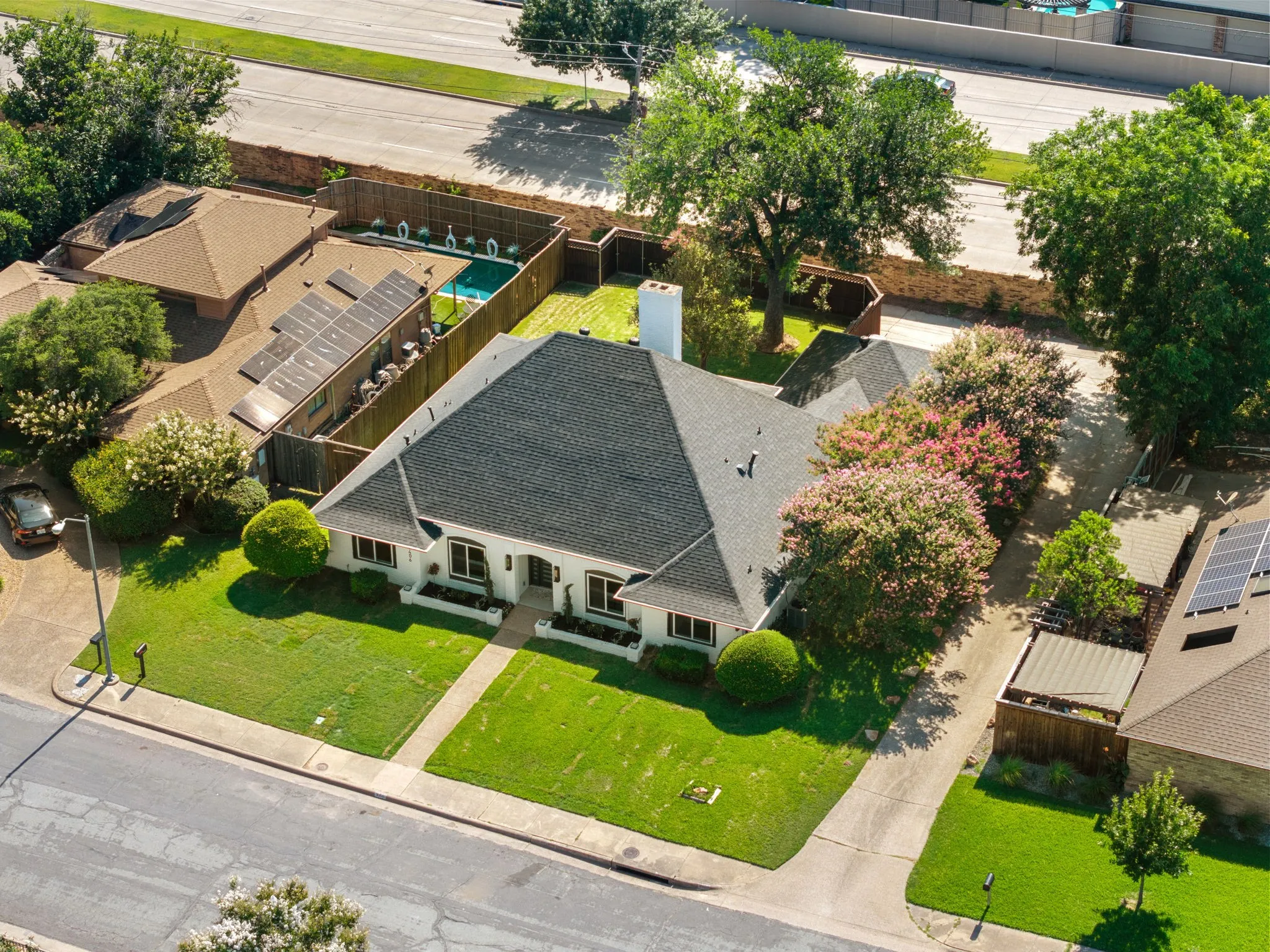 Single-story residence featuring a dark shingle roof and a white exterior facade