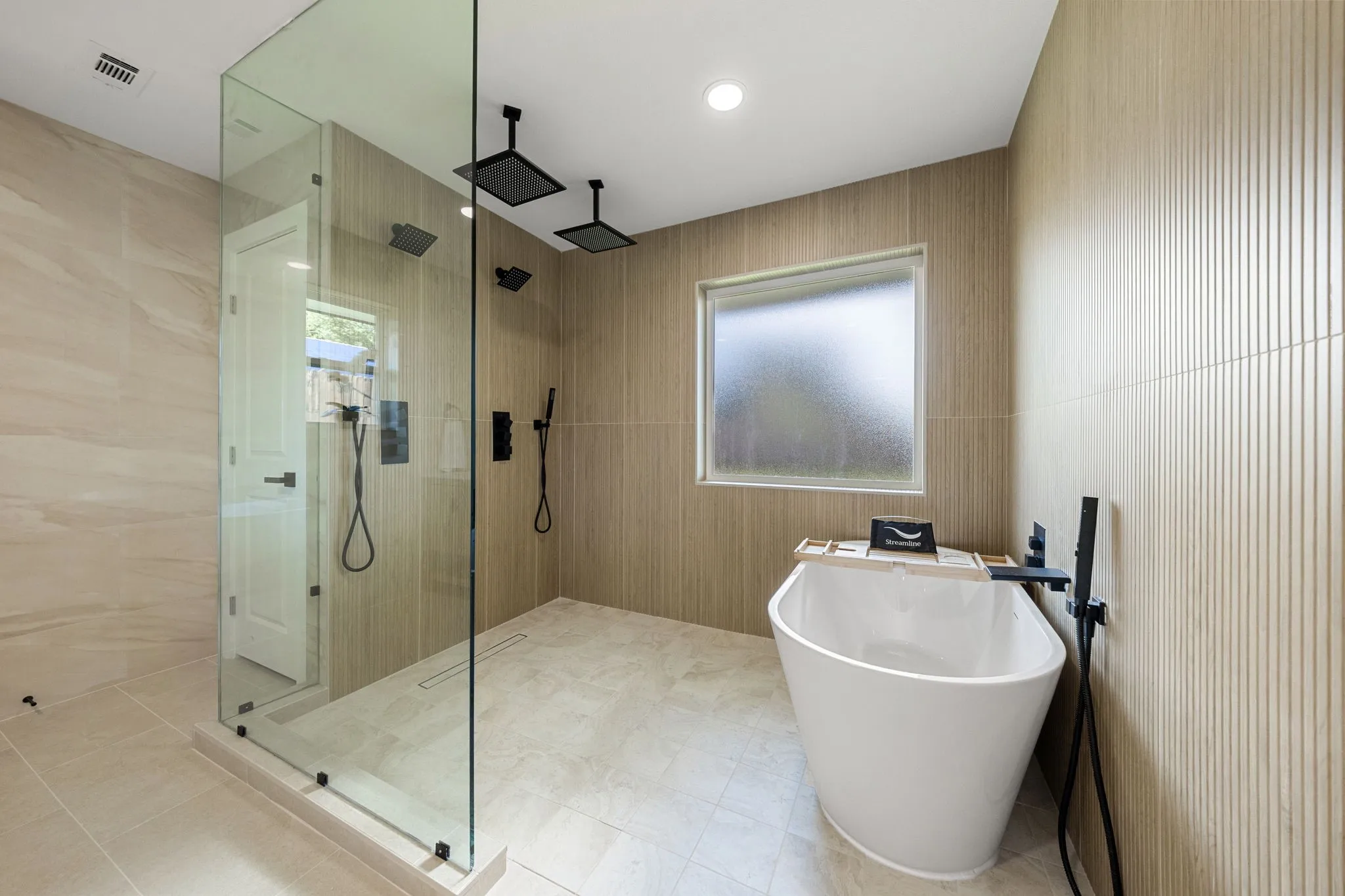 Freestanding soaking tub with a matte black floor-mounted faucet