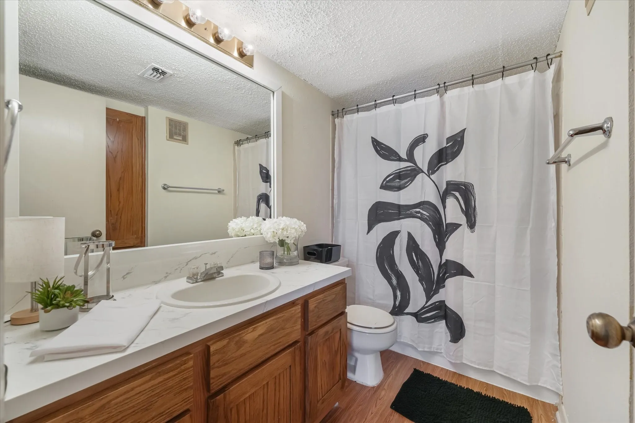 Bathroom featuring a wood-finish vanity with a white countertop and integrated sink