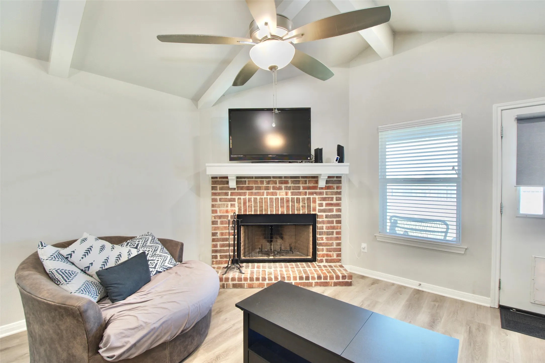 Vaulted ceiling with exposed white beams and a ceiling fan