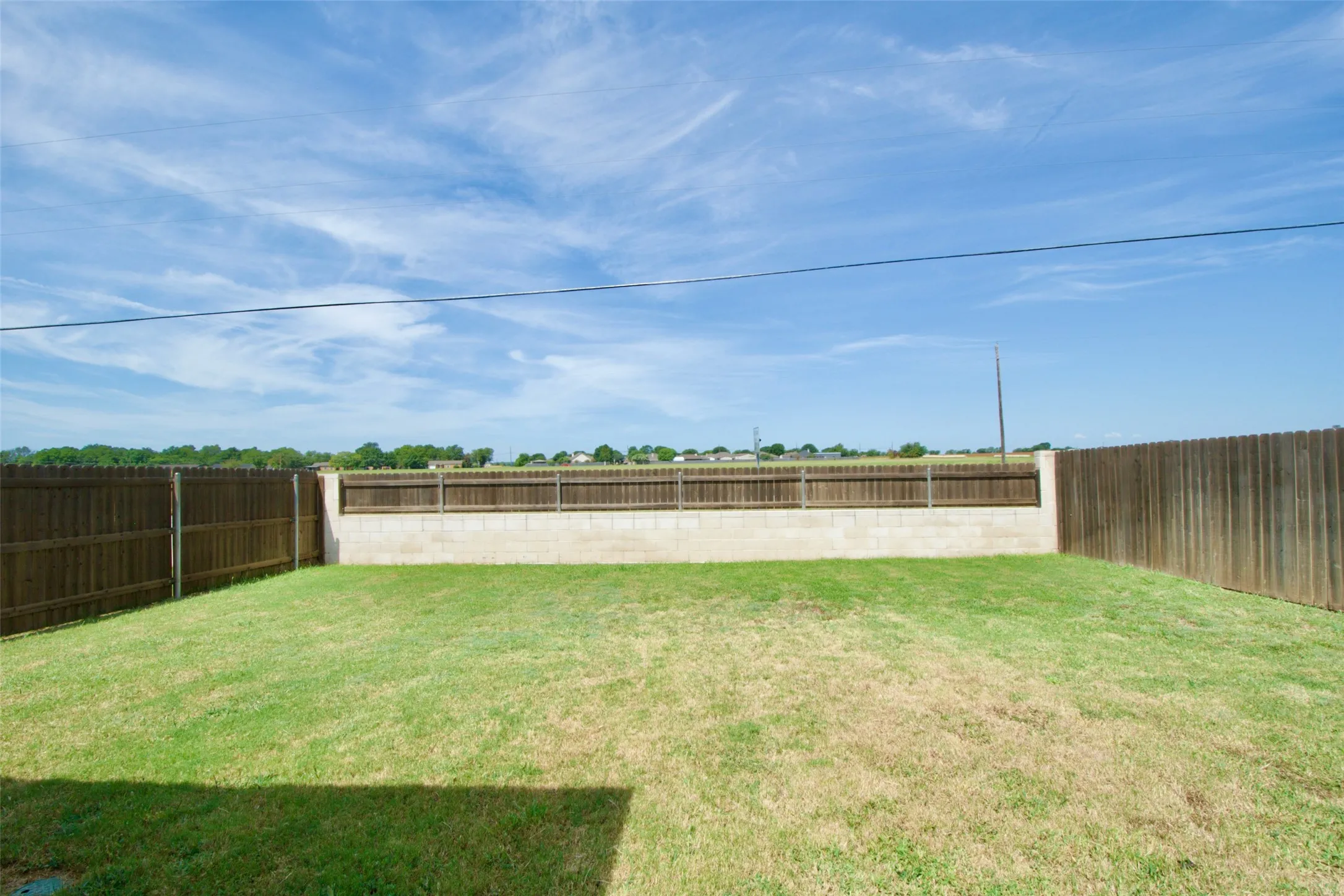 Expansive backyard featuring a combination wood and concrete block privacy fence