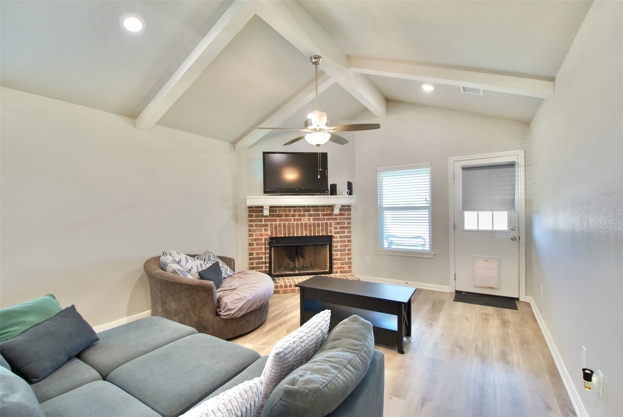 Living area featuring a vaulted ceiling with exposed beams, recessed lighting, and a ceiling fan