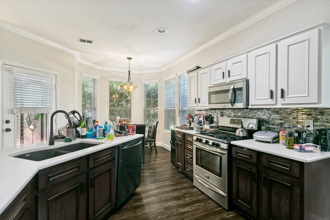 Modern kitchen featuring two-tone cabinetry with dark wood-finish lower cabinets and white upper cabinets
