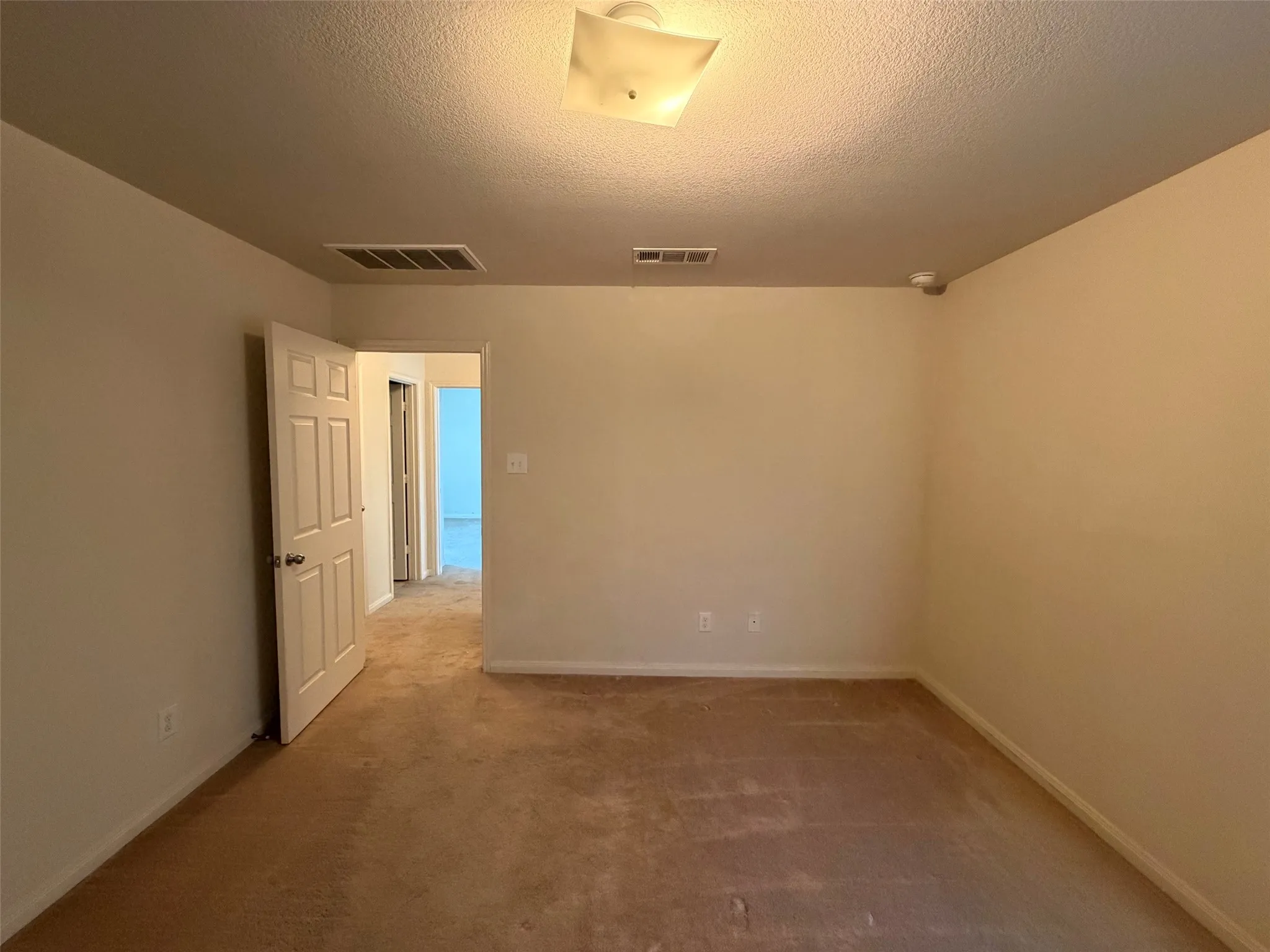 Neutral-toned walls complement the brown carpeting throughout this interior space