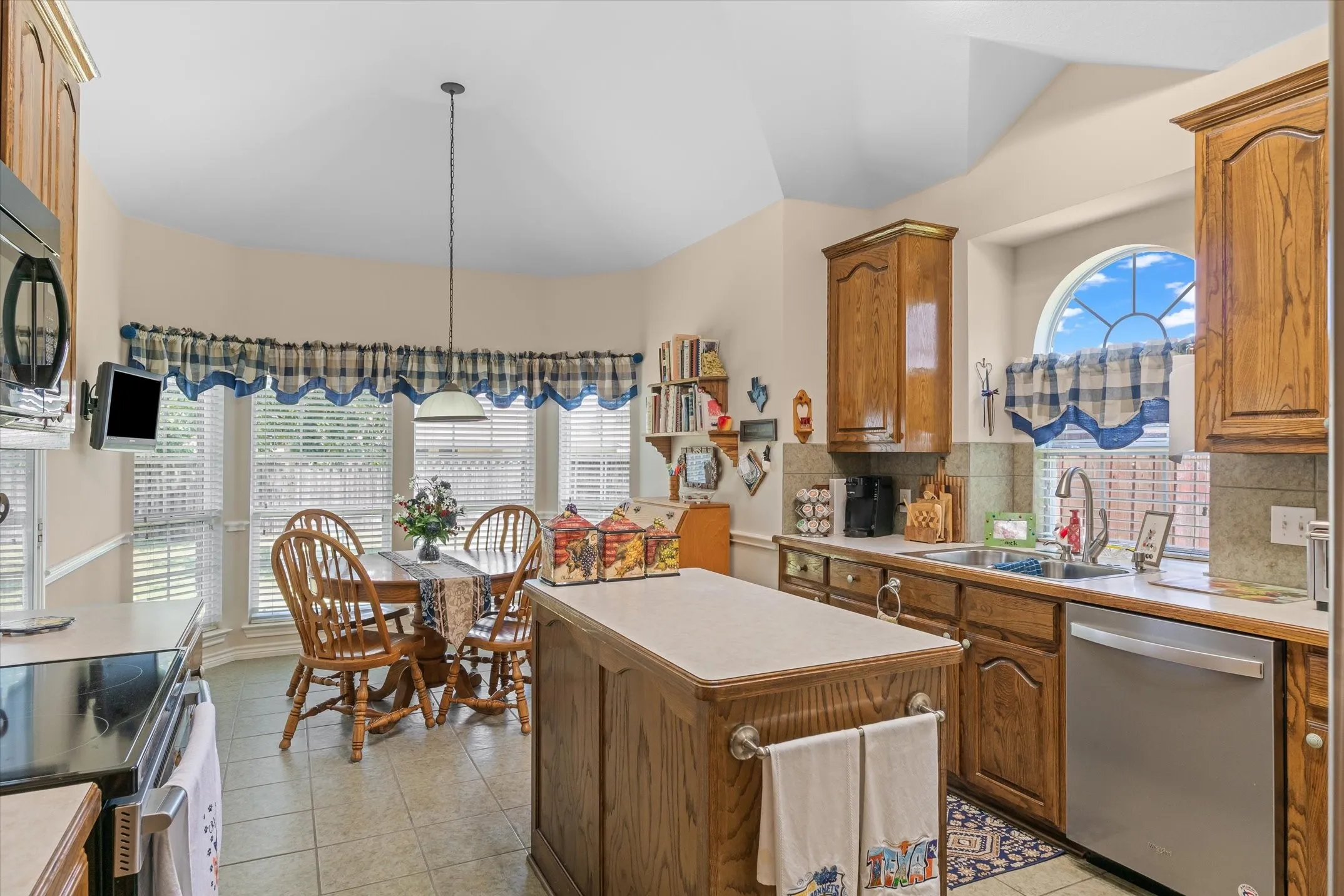 Kitchen featuring wood-finish cabinetry, a central island with countertop, and tile flooring