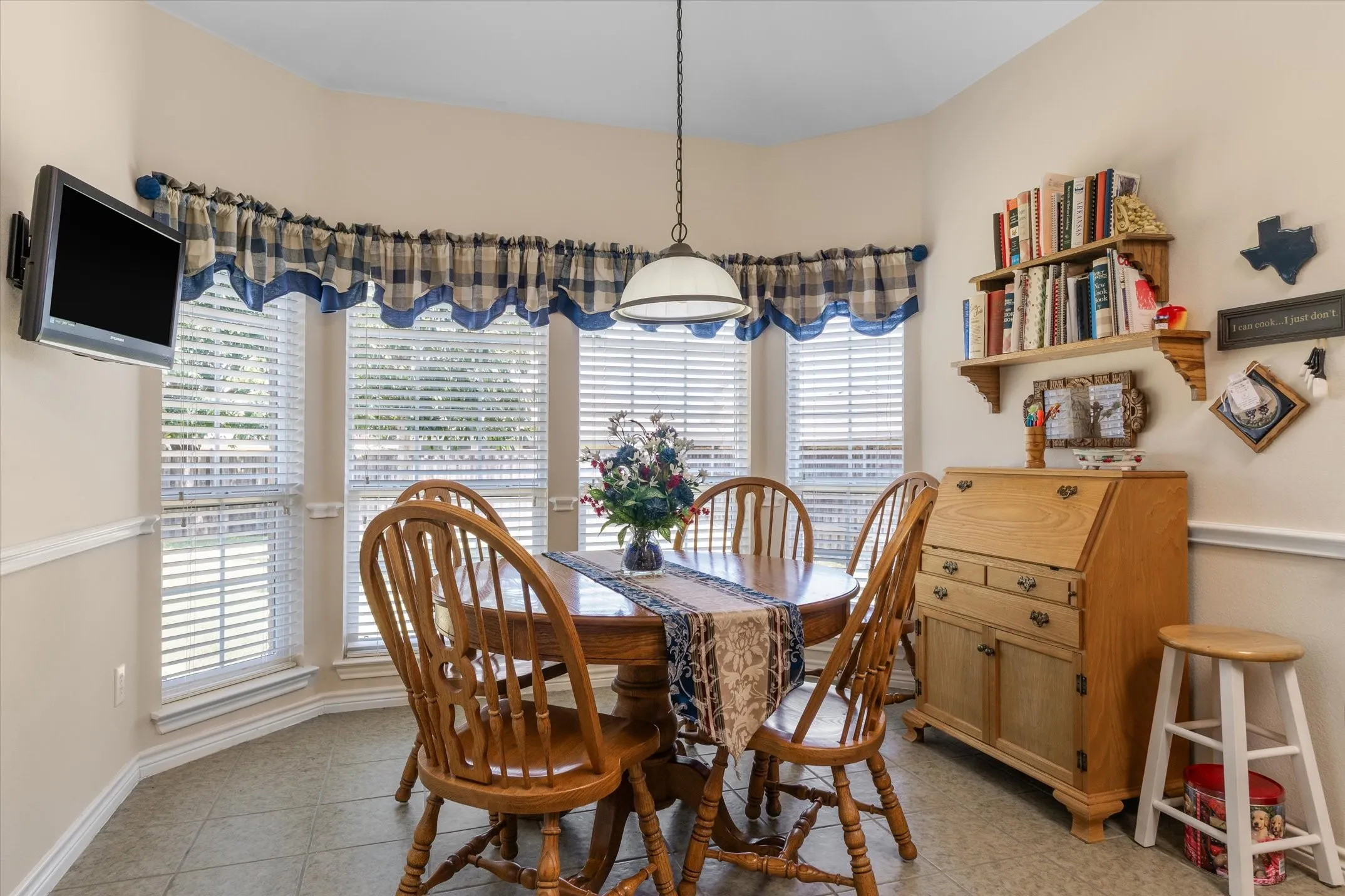 Bay window area featuring tile flooring, neutral wall tones, and white trim