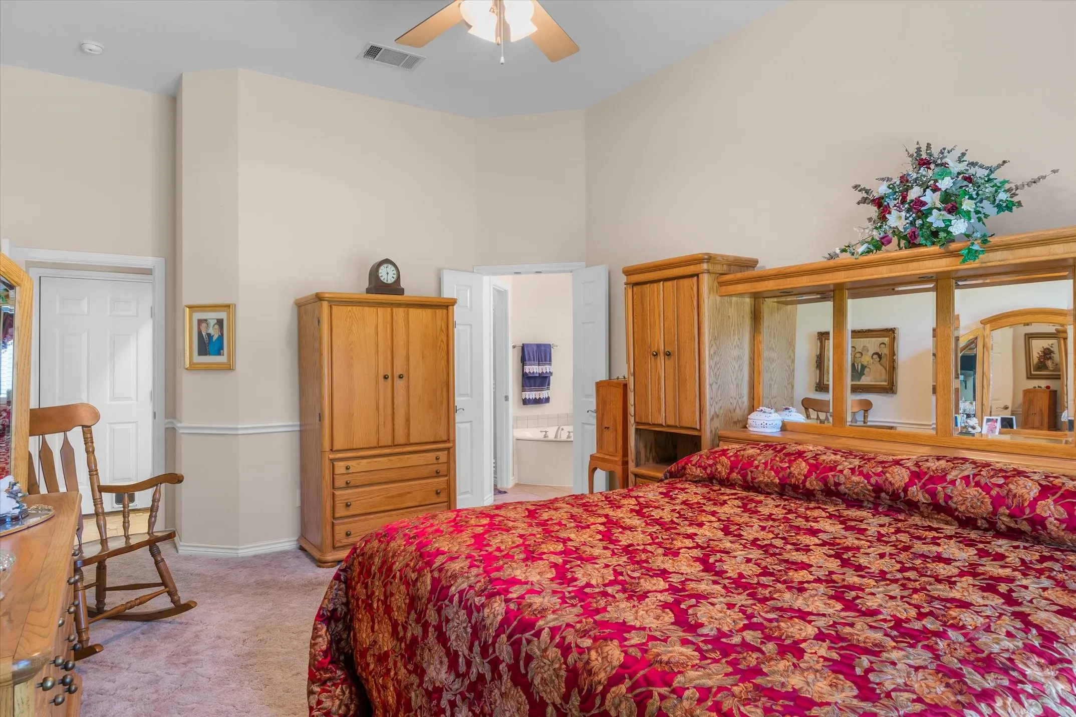 Spacious room featuring vaulted ceilings, neutral wall tones, and plush carpeting