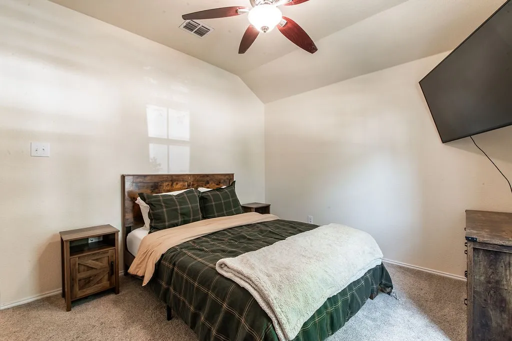 Carpeted room featuring an angled ceiling and neutral wall tones