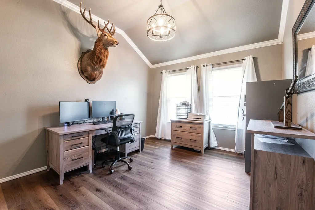Vaulted ceiling with a decorative light fixture, wood-finish flooring, and white trim