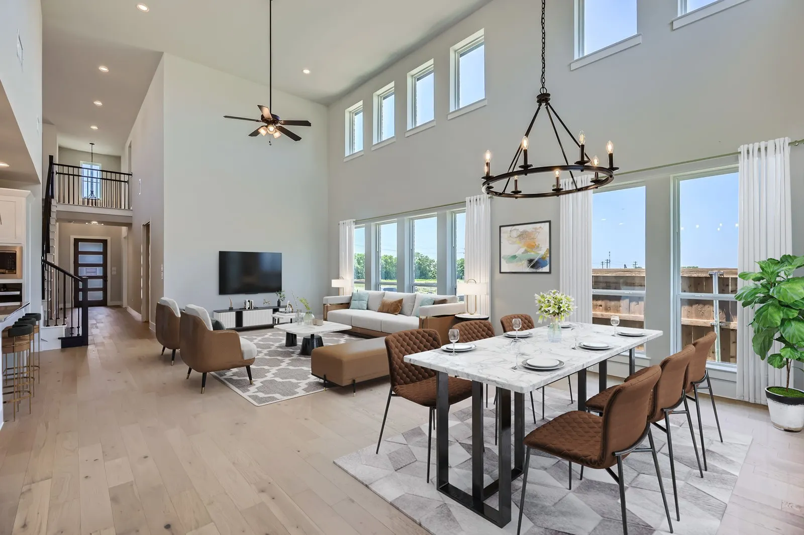 Expansive main living area featuring high ceilings, wood-finish flooring, and abundant natural light from numerous windows