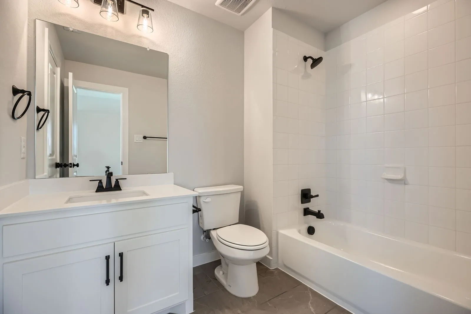 Full bathroom featuring a white vanity with a rectangular sink, matte black faucet, and white countertop