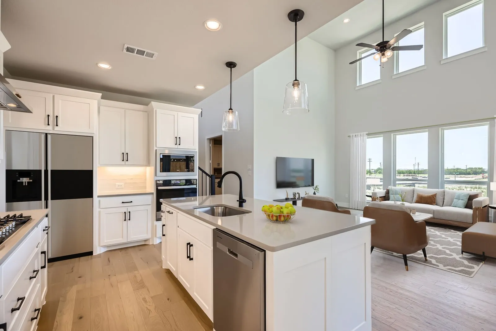 Open-concept living space with a kitchen island featuring a stainless steel sink and dishwasher