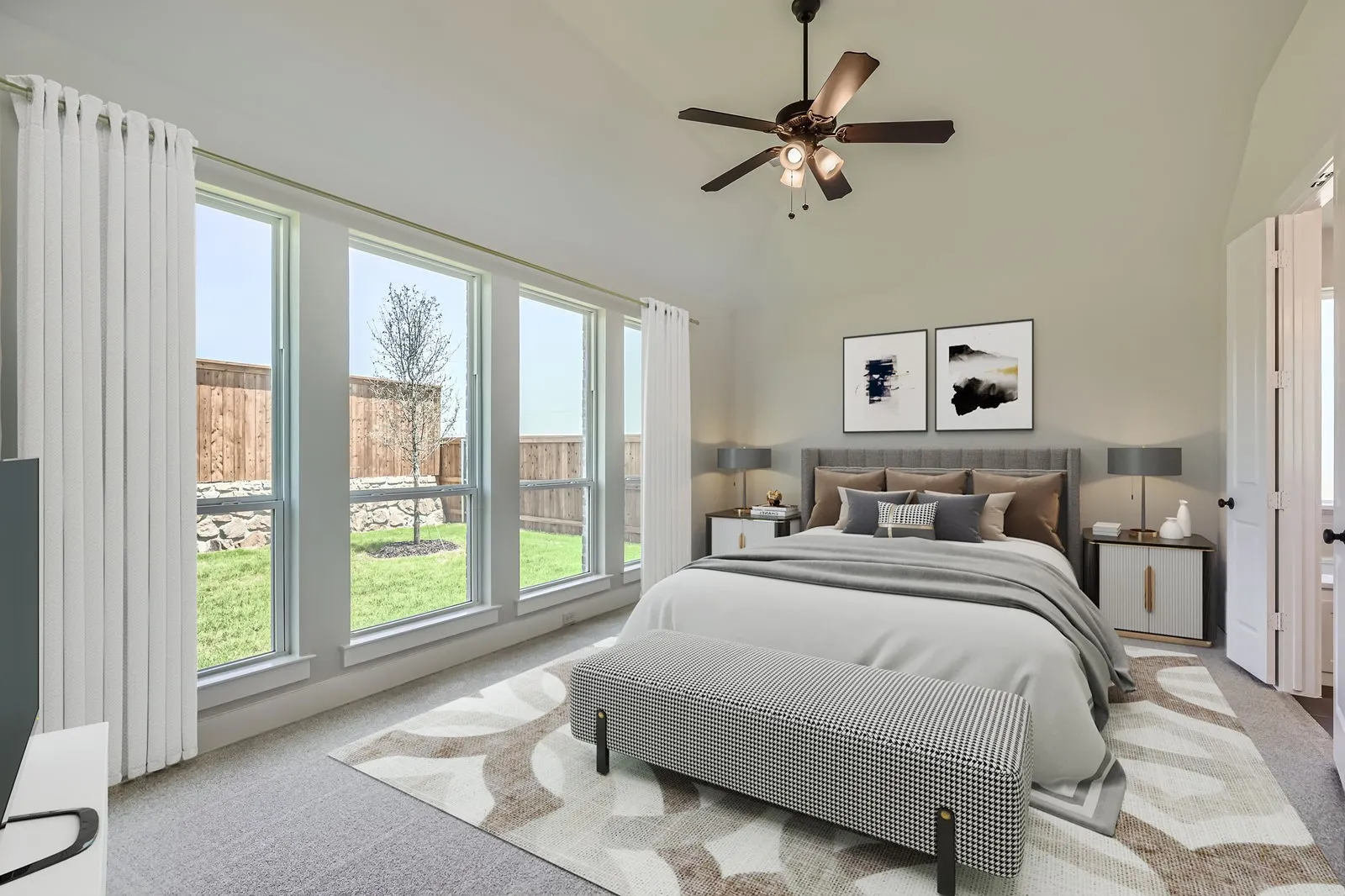 Light-filled bedroom featuring a vaulted ceiling and a ceiling fan with integrated lighting