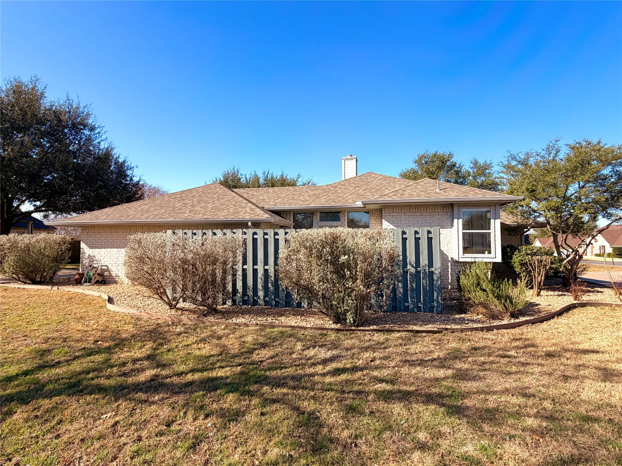 Side of house featuring a private patio, accessible from the dining room and enclosed by a fence.