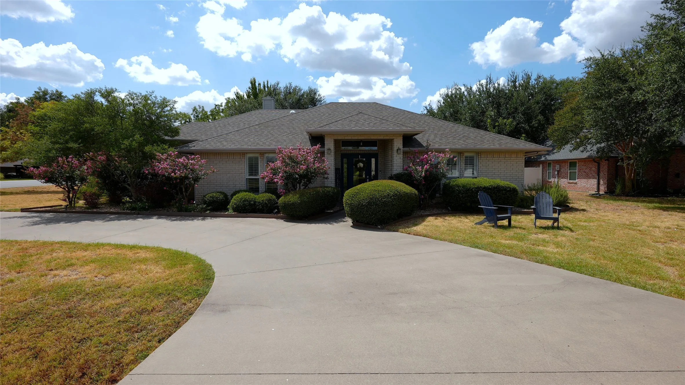 5614 Wedgefield-3 bedroom 3 full bath 2,040 SF. Single-story residence featuring a gray shingle roof, light-colored brick exterior, and a circle driveway