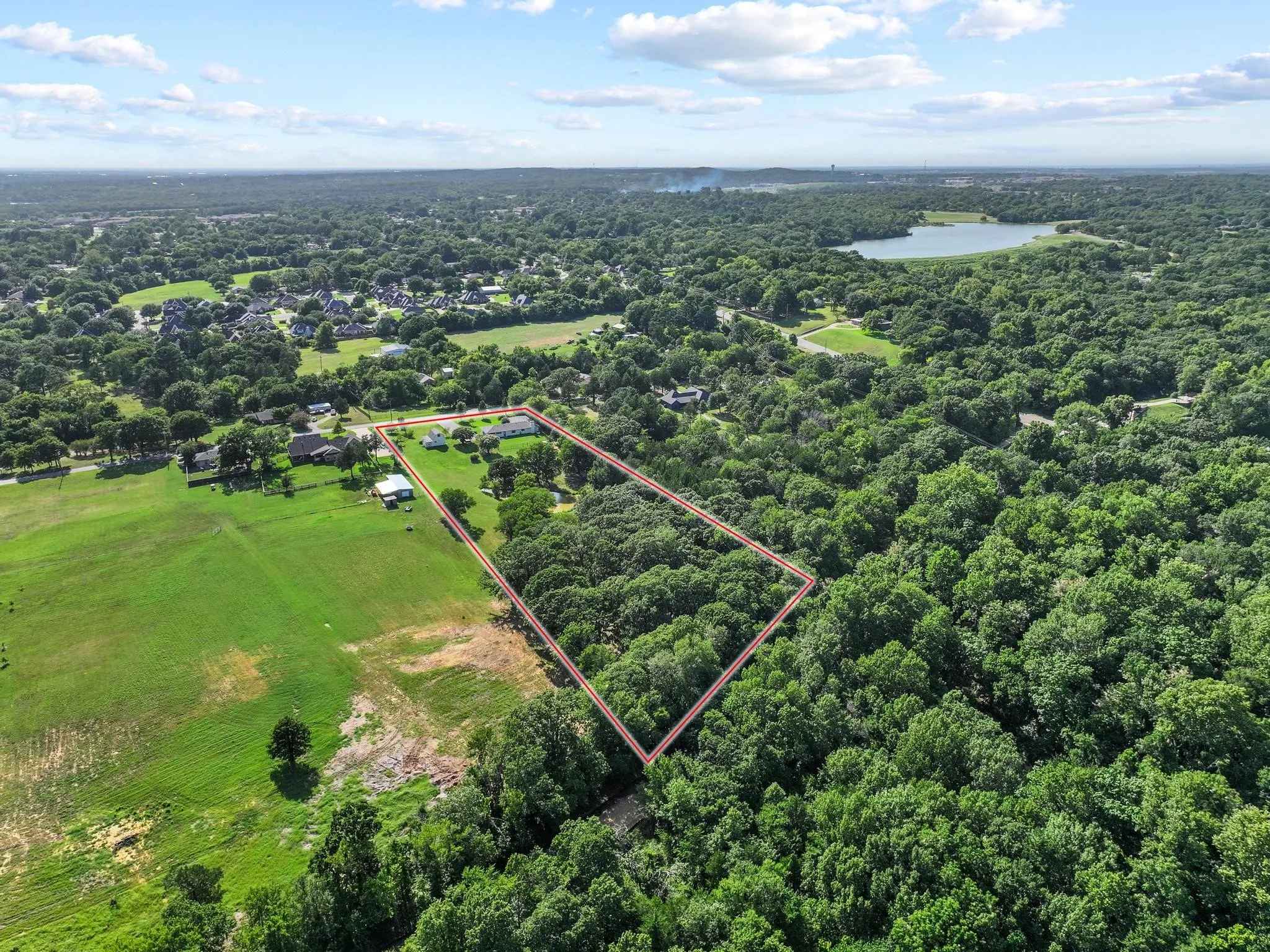 Expansive wooded acreage outlined by a red boundary, surrounded by a verdant landscape