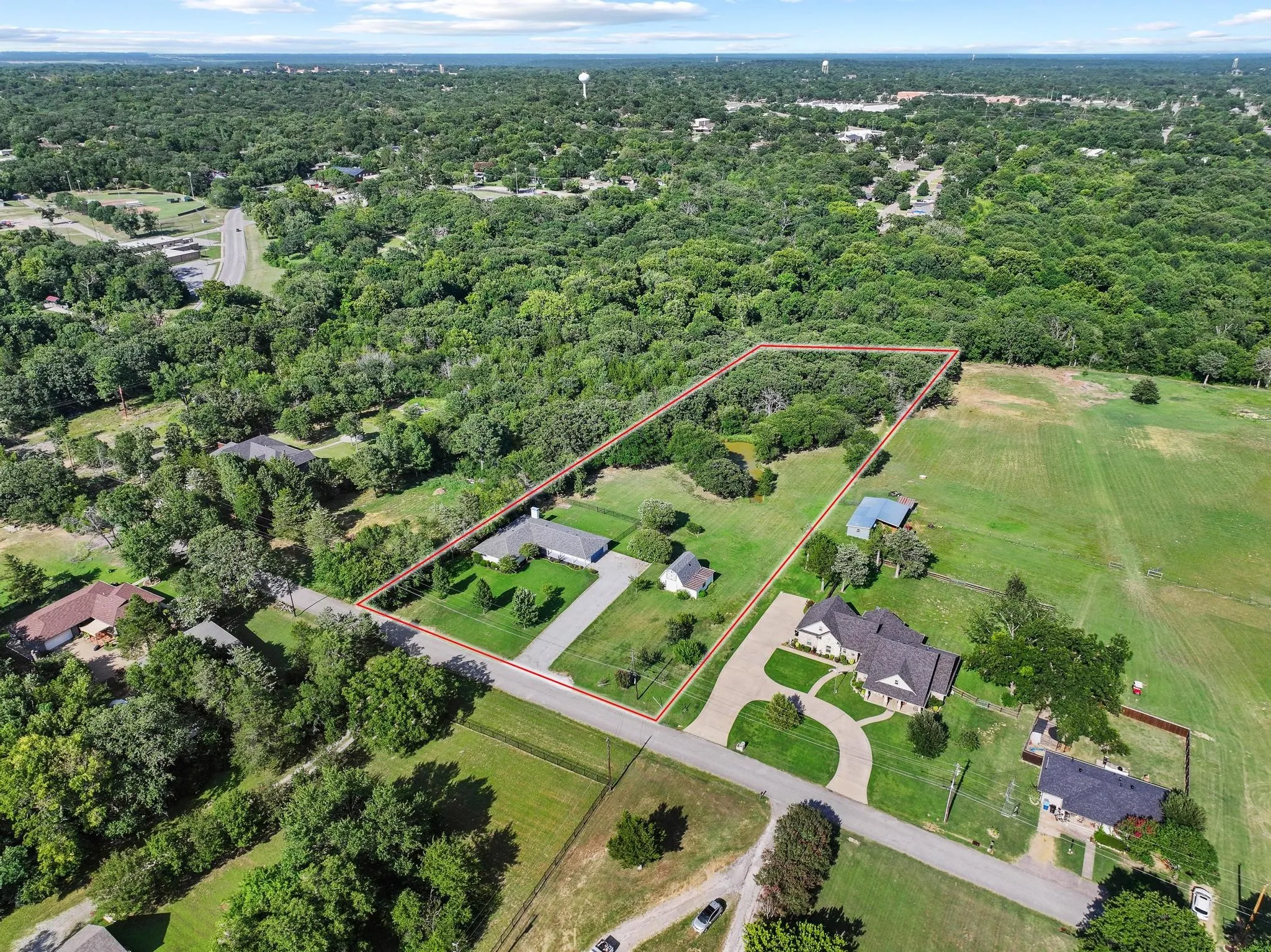 Aerial perspective showcasing a large residential lot with extensive green space