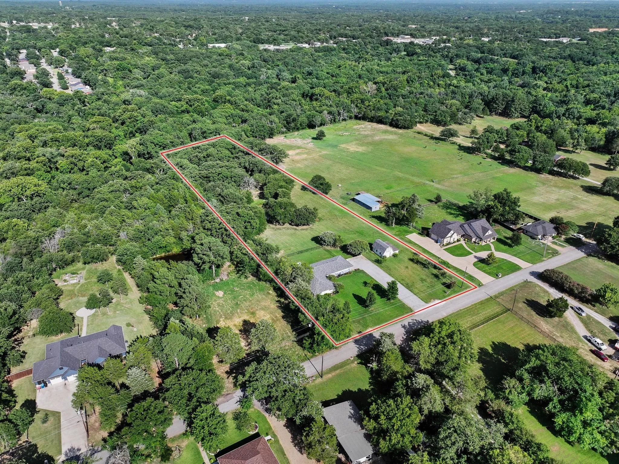 Expansive property featuring a mix of mature trees and open green space