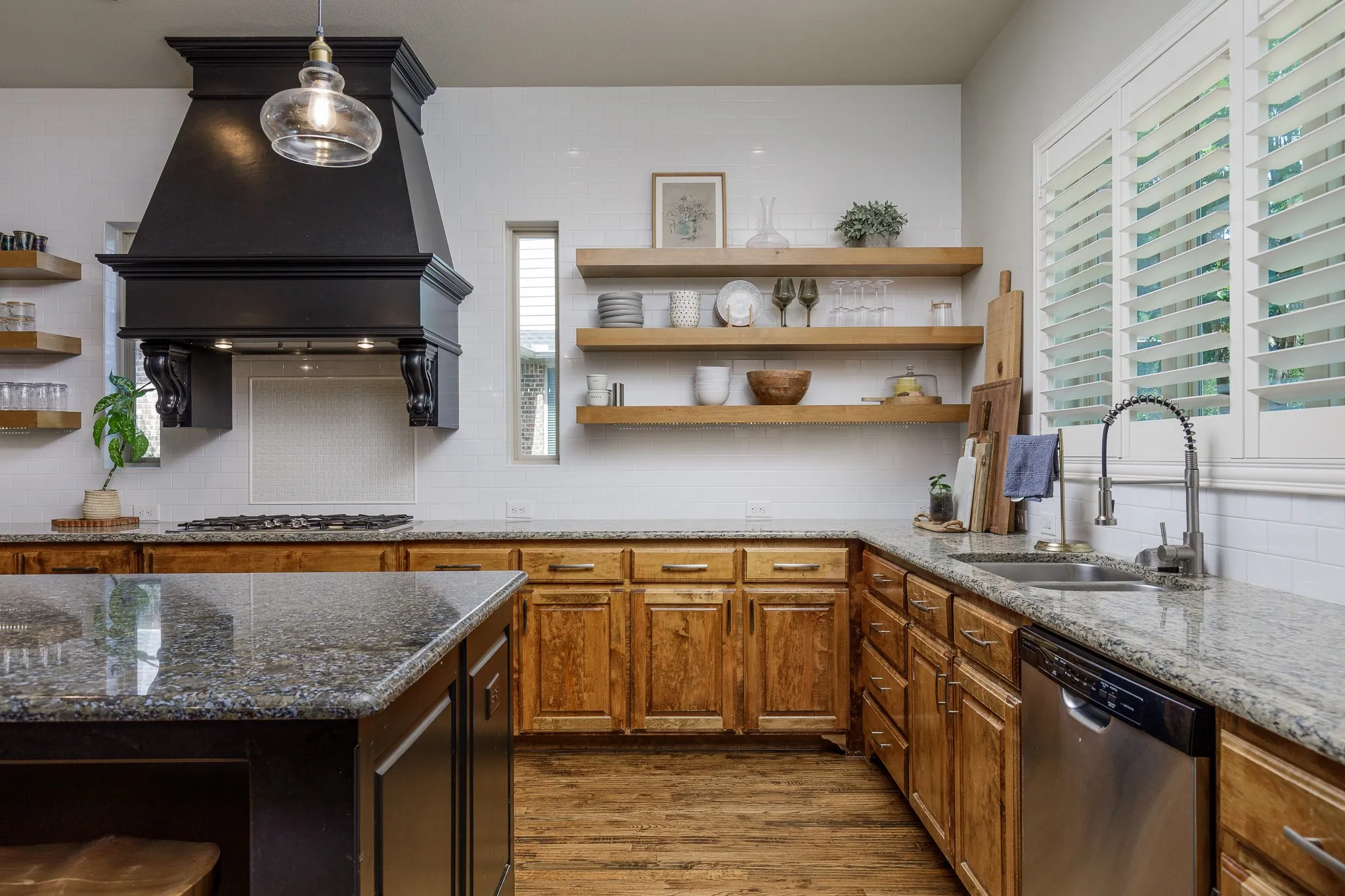 Kitchen features subway tile and floating shelves