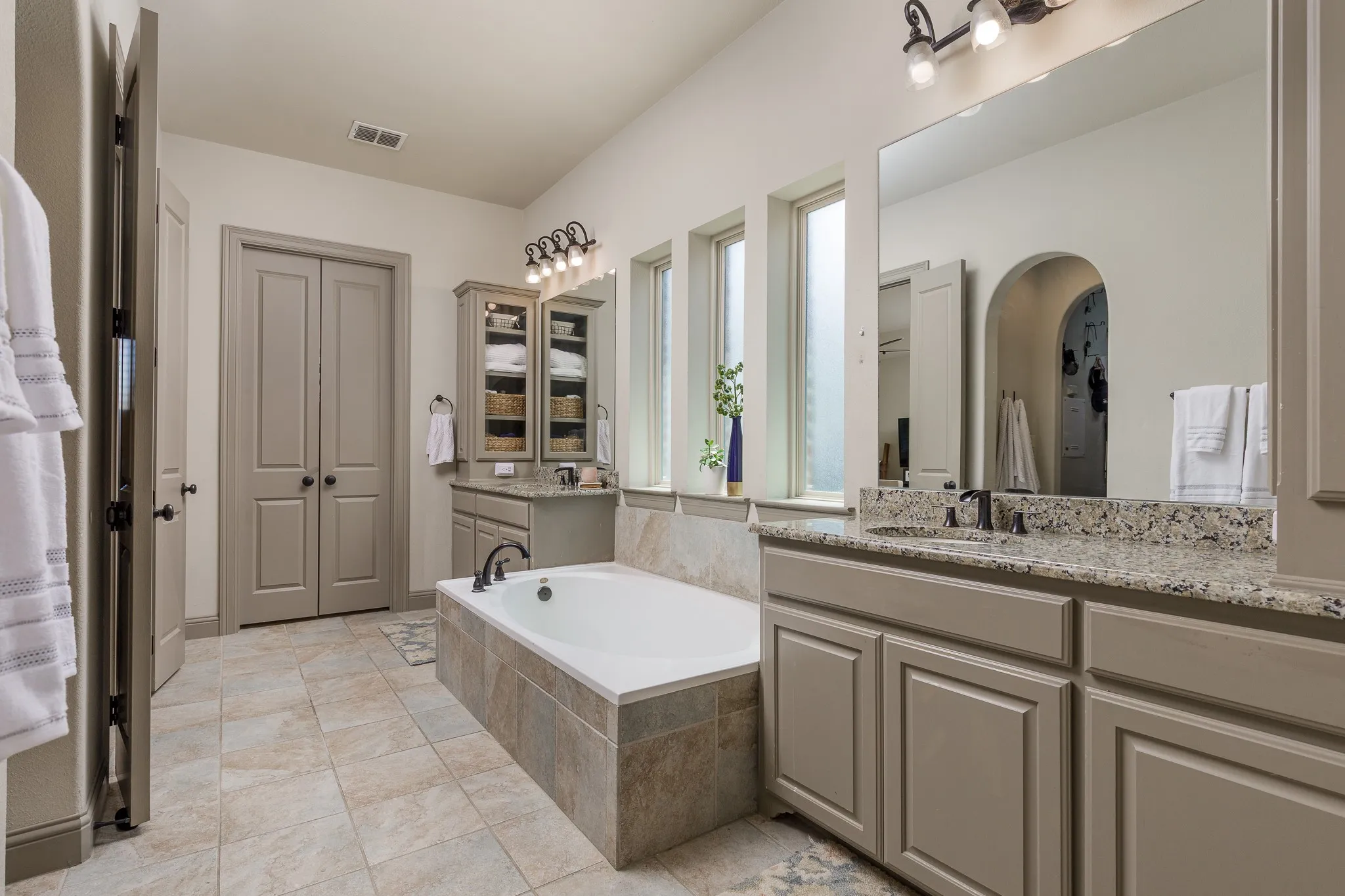 Primary bathroom features a garden tub, separate shower, dual vanities, and dual closets.