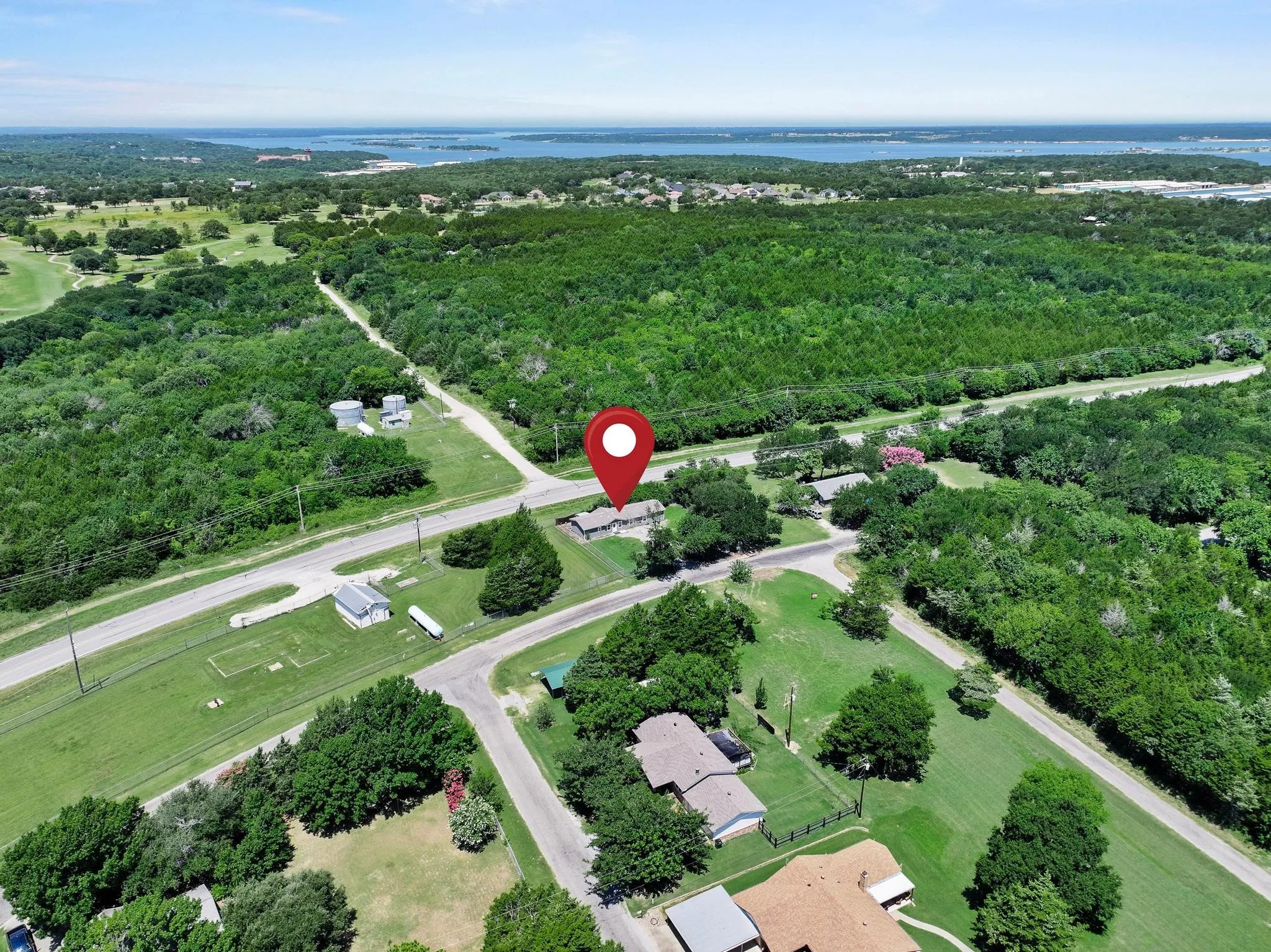 Expansive land parcel featuring road frontage, mature trees, and proximity to a large body of water