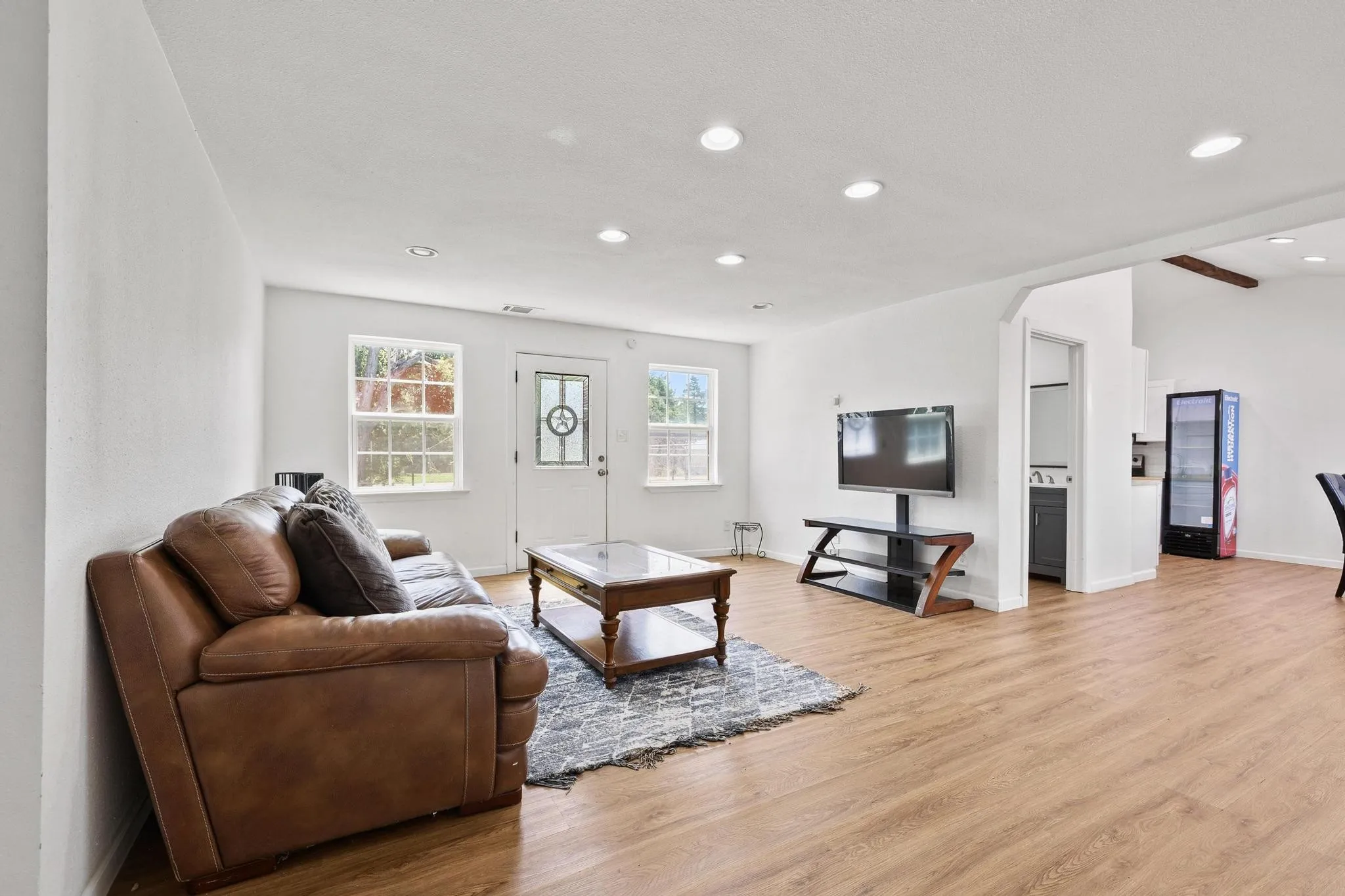 Open-concept living space featuring wood-finish flooring and recessed lighting