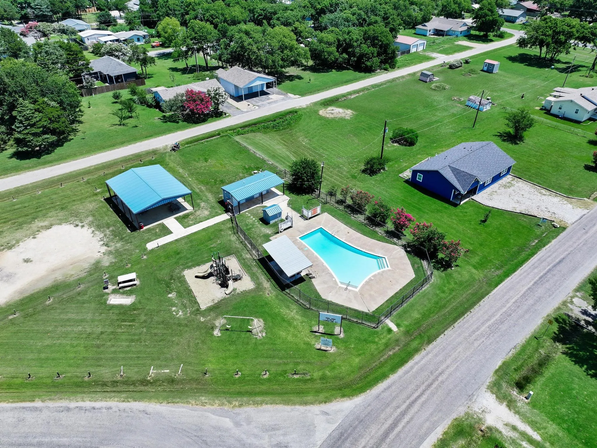 In-ground swimming pool with surrounding fence and concrete decking