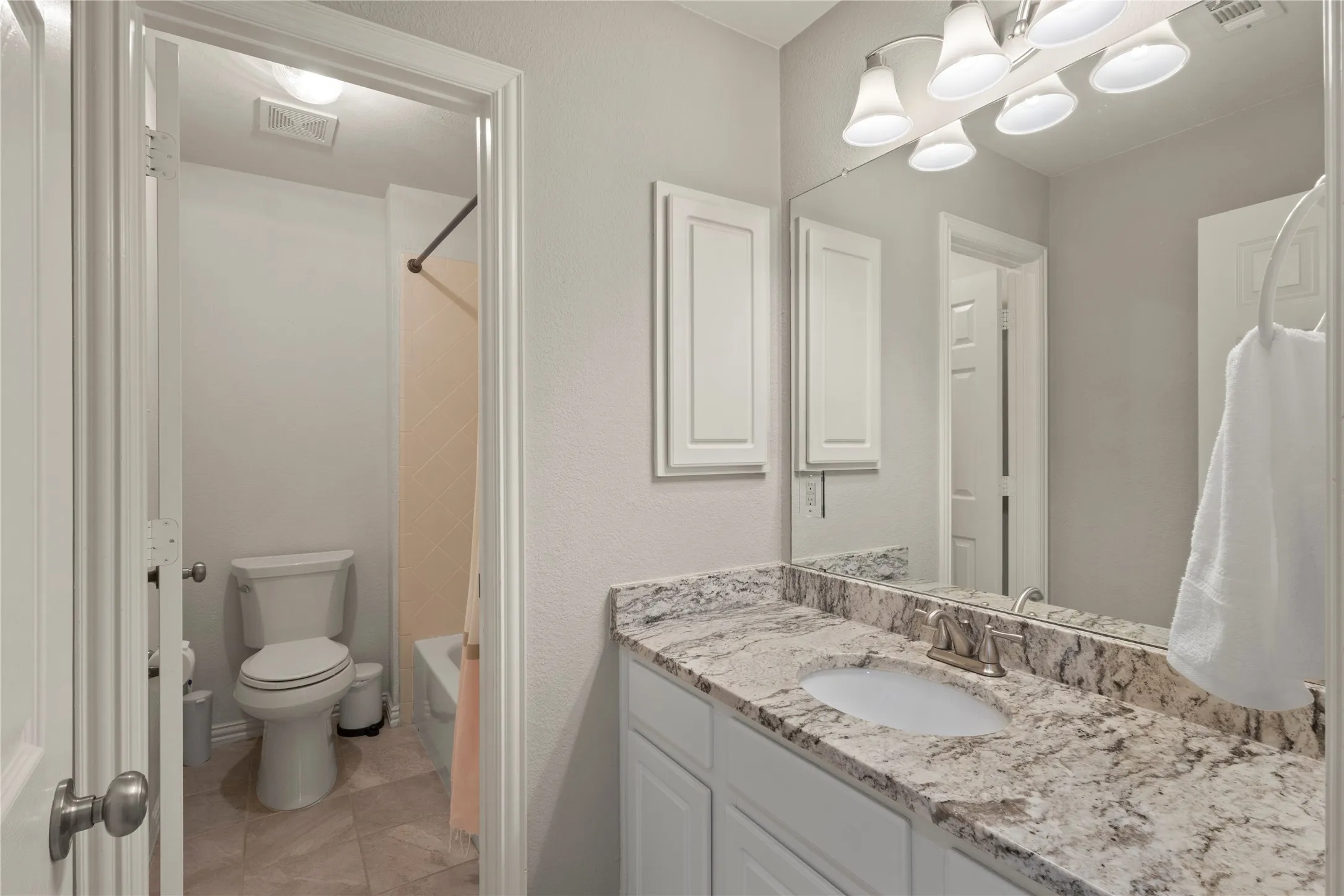 Upstairs hall bathroom with separate toilet and shower area, granite countertops