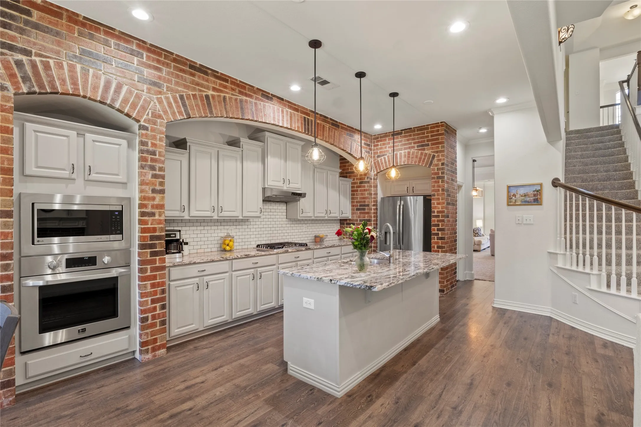 Open concept family room. Granite countertops, brick accent wall, LVP flooring.