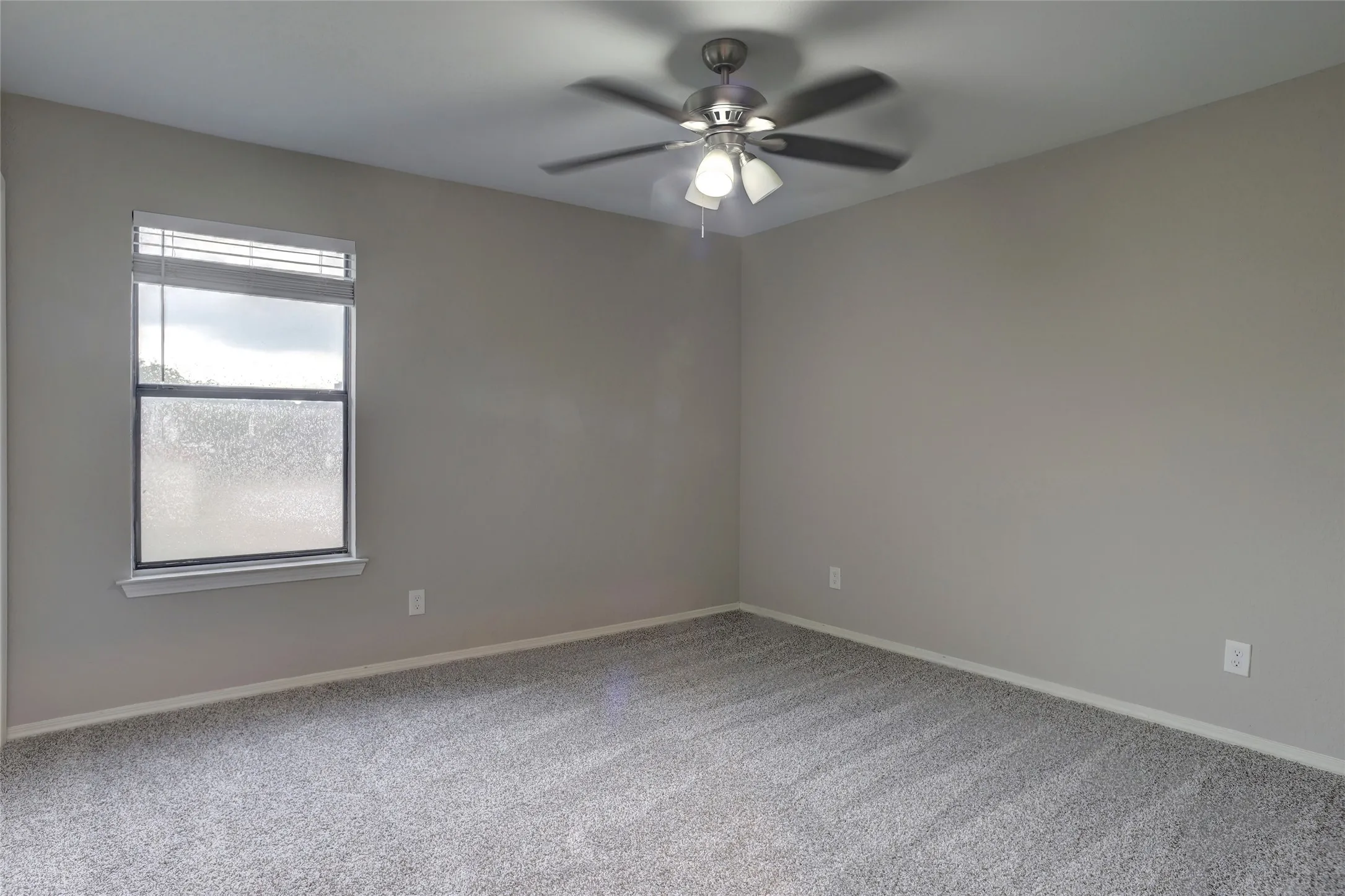Room featuring light gray wall paint and complementary gray carpet flooring