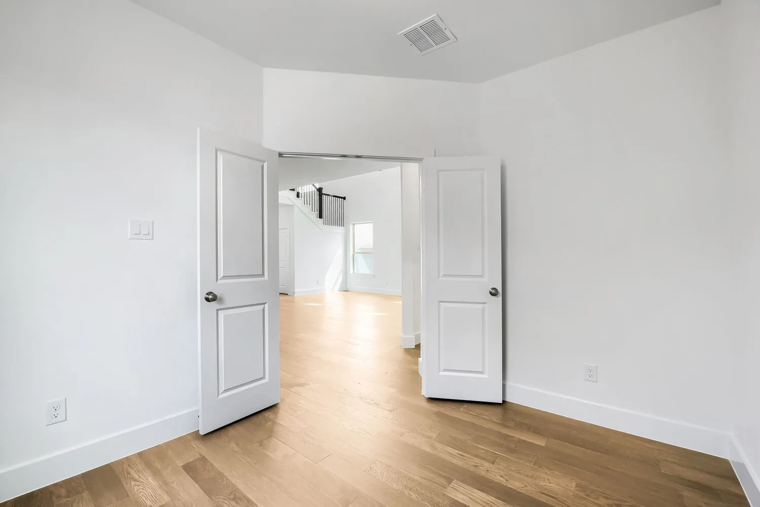 Light wood-finish flooring, white walls, and bright white trim throughout