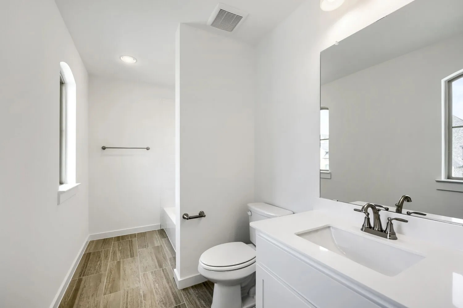 White vanity with an integrated sink and brushed nickel faucet