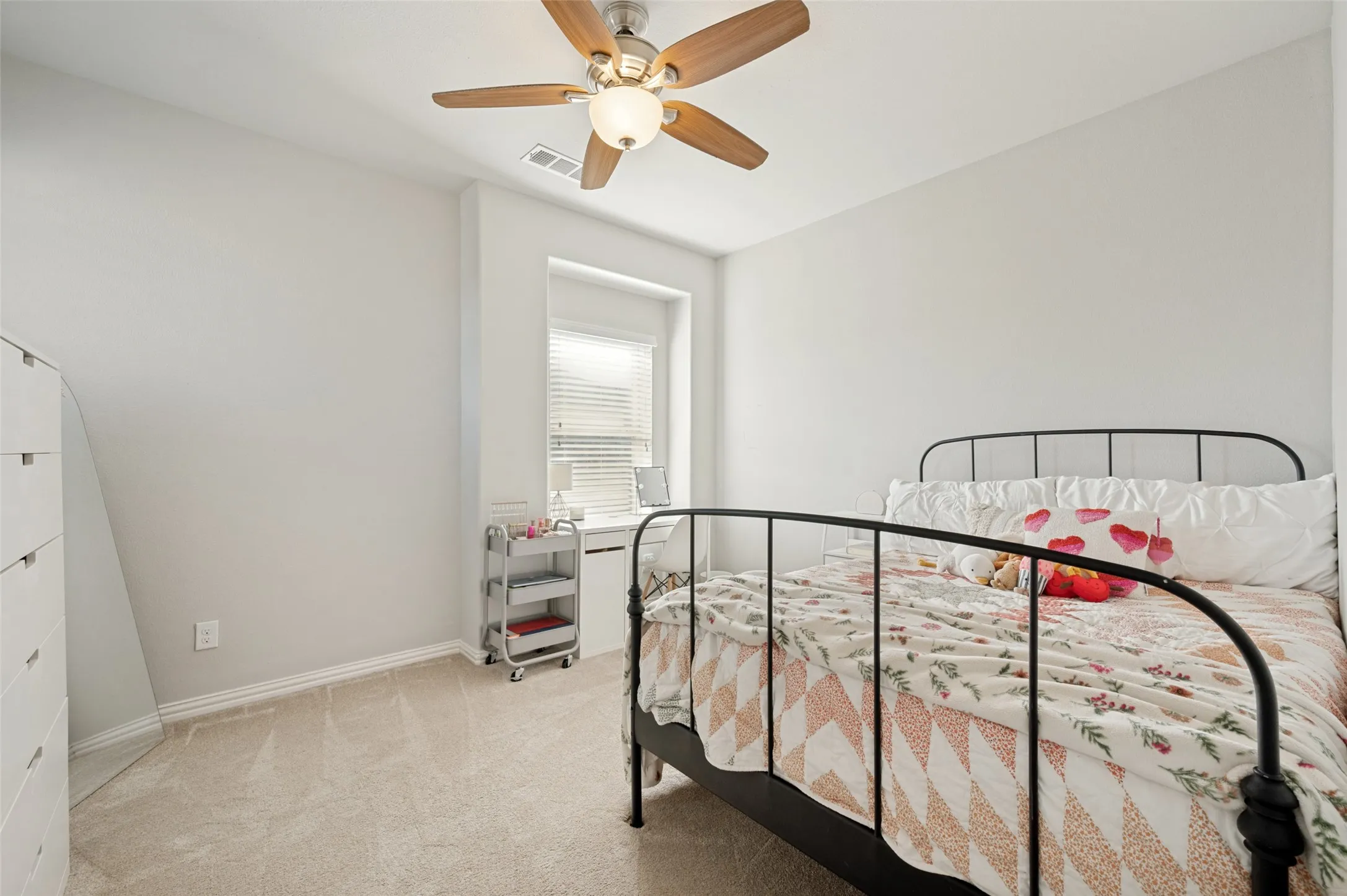 Carpeted room with a ceiling fan, recessed window, and white horizontal blinds