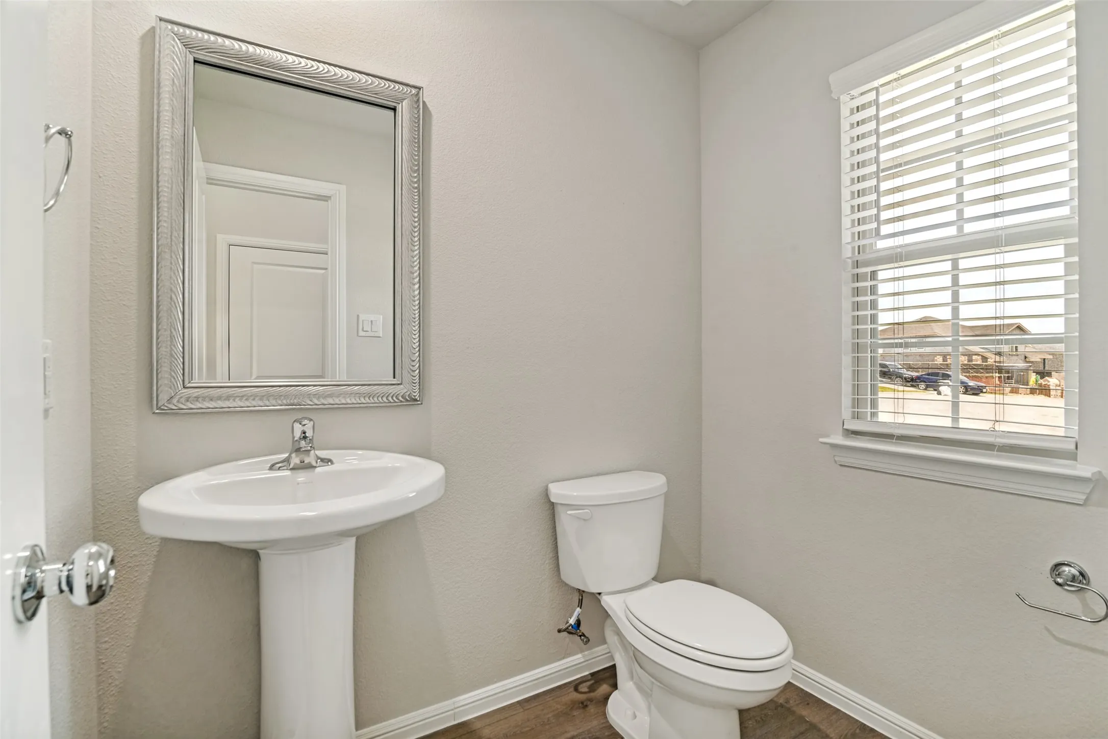 Guest 1/2 bath near entrance. Pedestal sink with chrome faucet and framed mirror