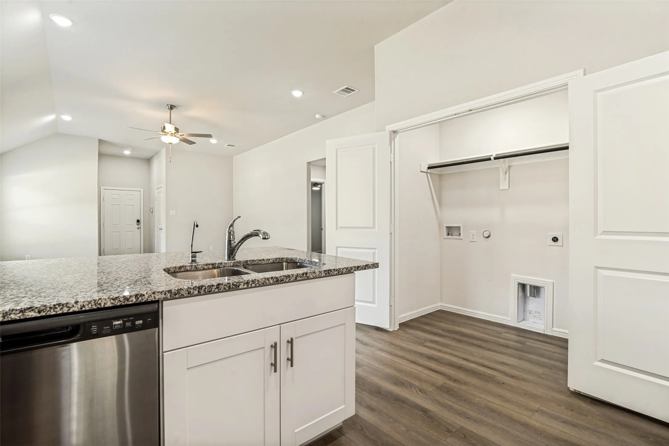 Kitchen island featuring a double basin sink and stainless steel dishwasher