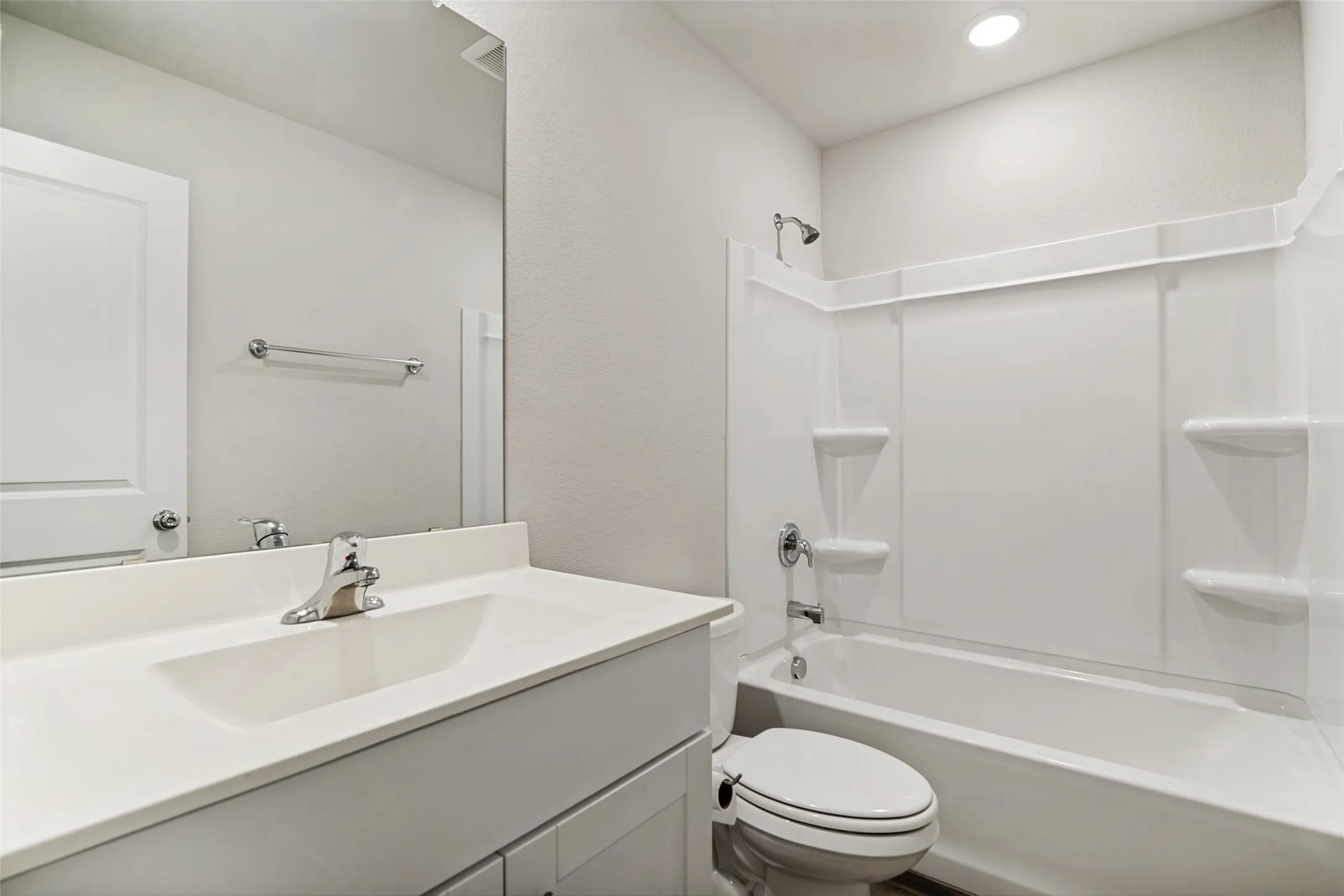 Bathroom featuring a single vanity with an integrated sink, chrome faucet, and a large mirror