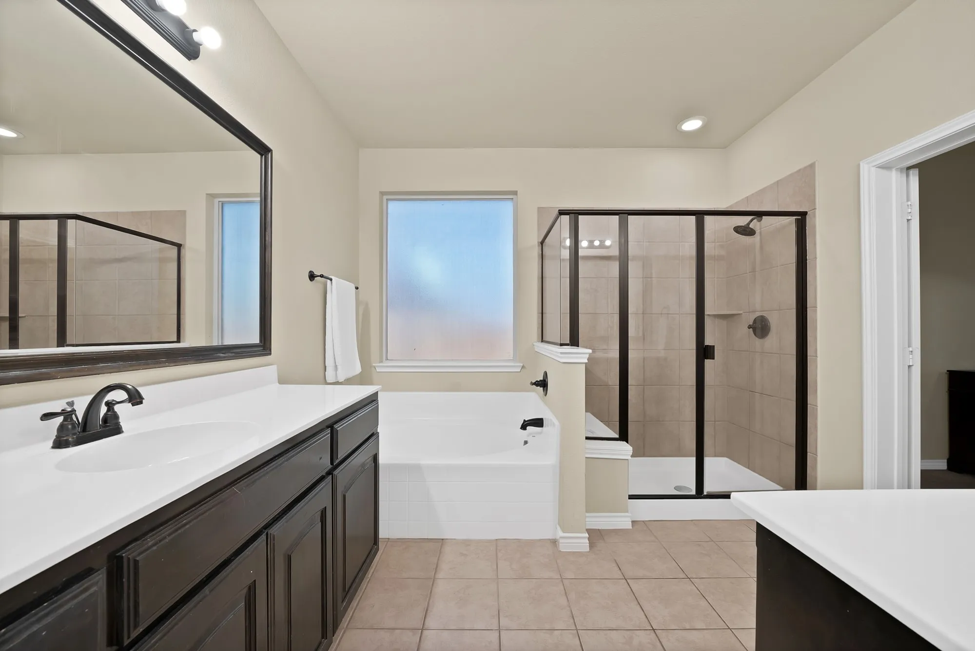 Primary bathroom with separate sinks, tub and shower