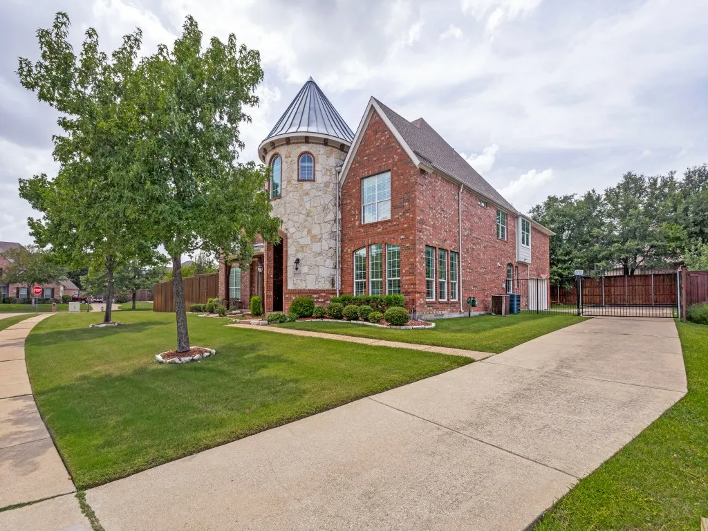 Two-story brick and stone exterior featuring a prominent turret with a conical roof